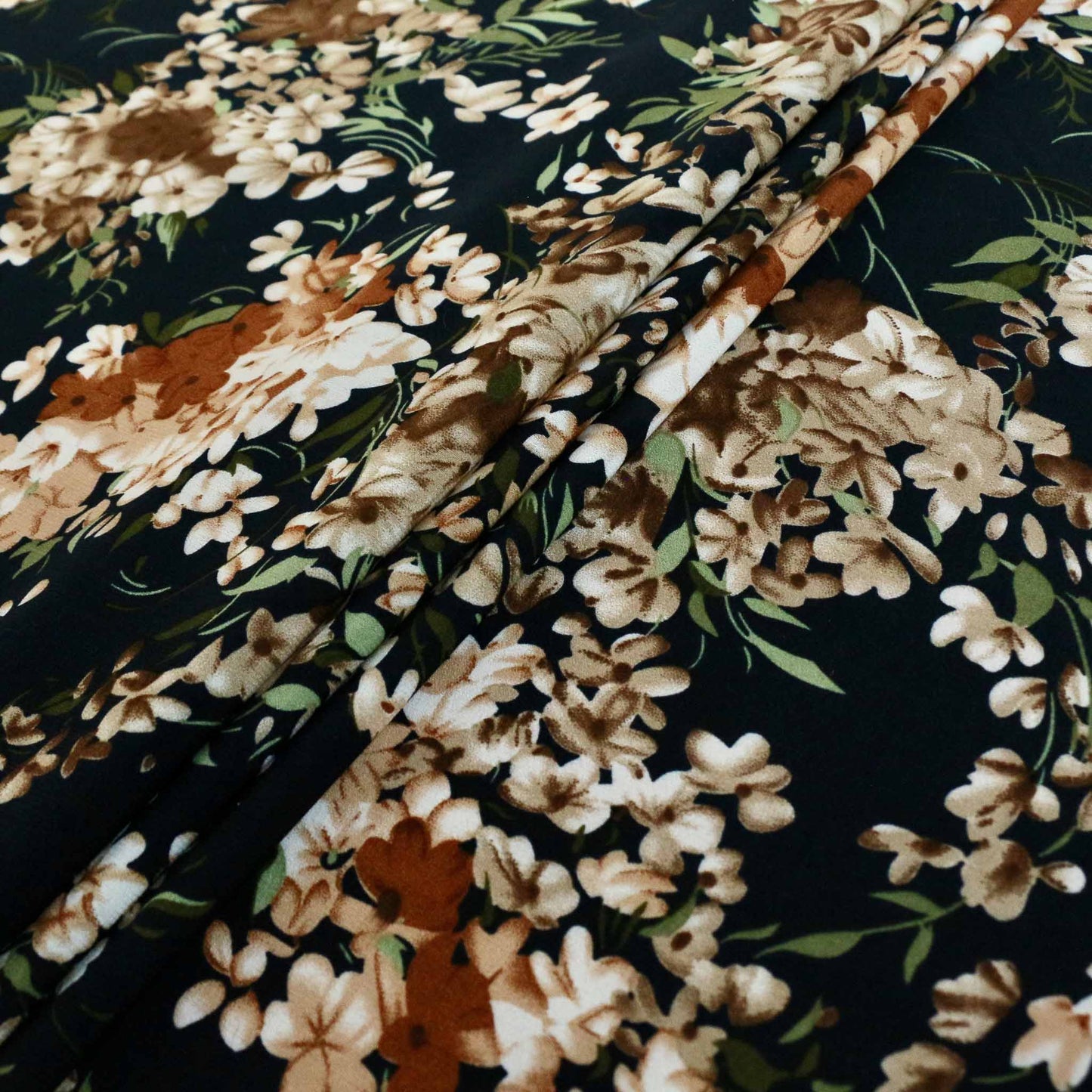 folded brown floral printed flowers on black chiffon synthetic stretchy dressmaking fabric