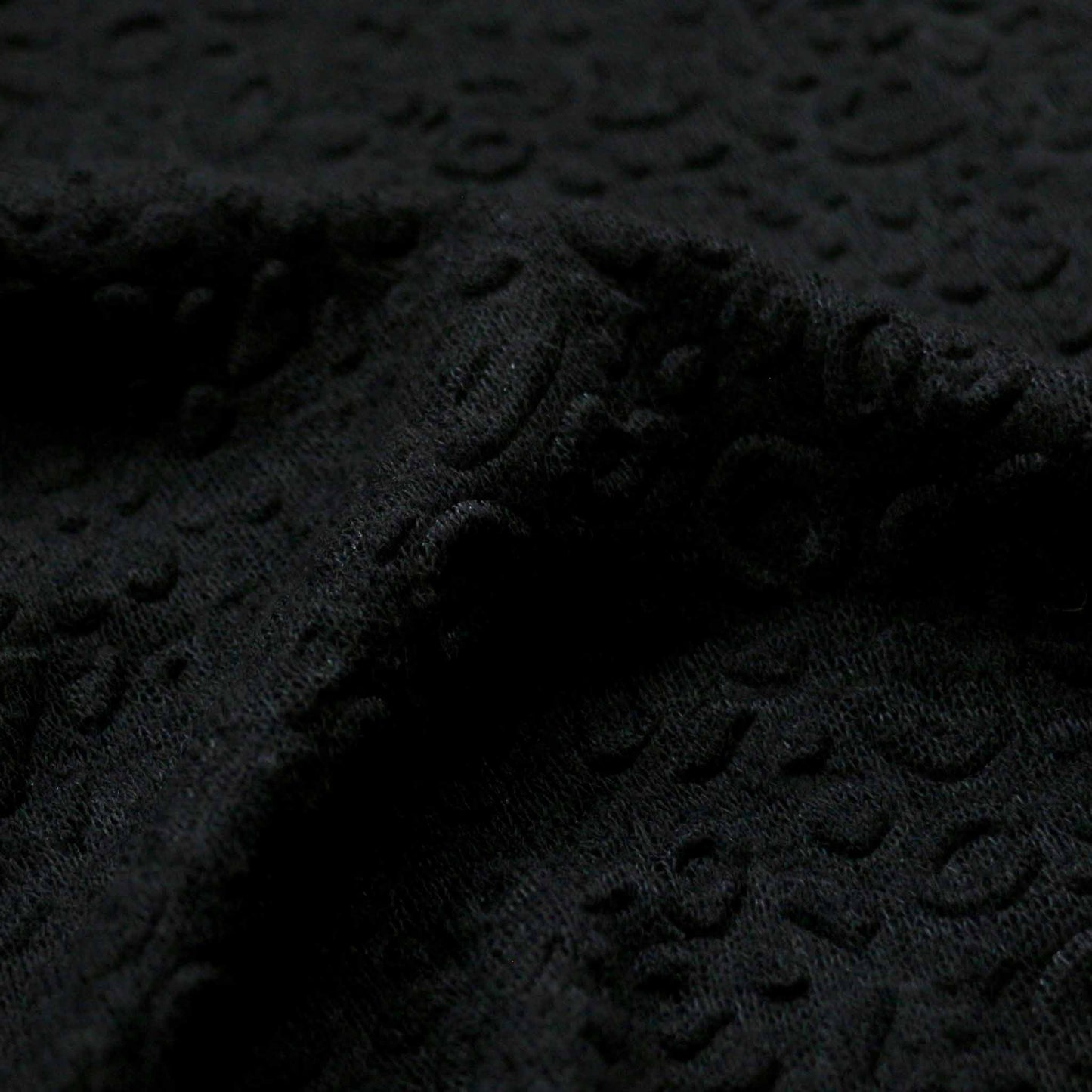 jersey knit dressmaking fabric in black with decorative embossed texture design