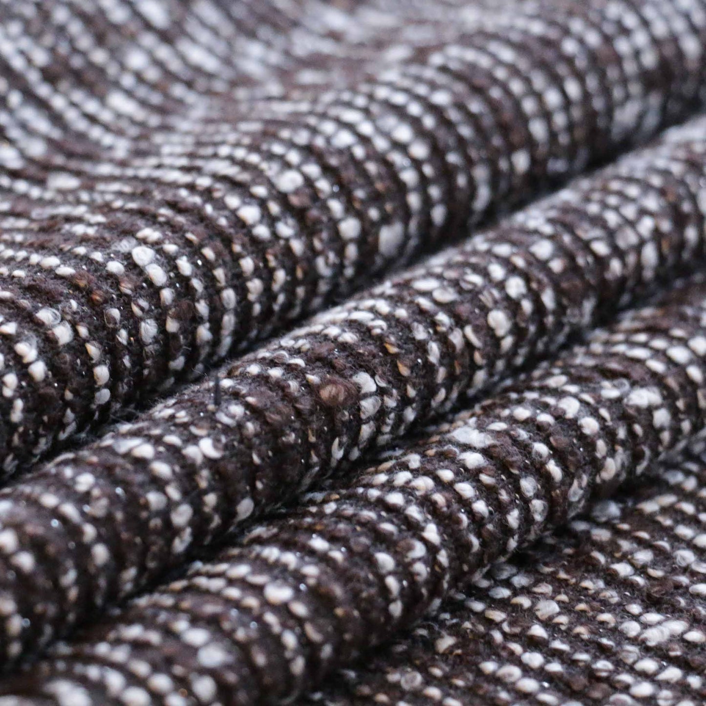 folded brown boucle wool blend dressmaking fabric with silver yarn