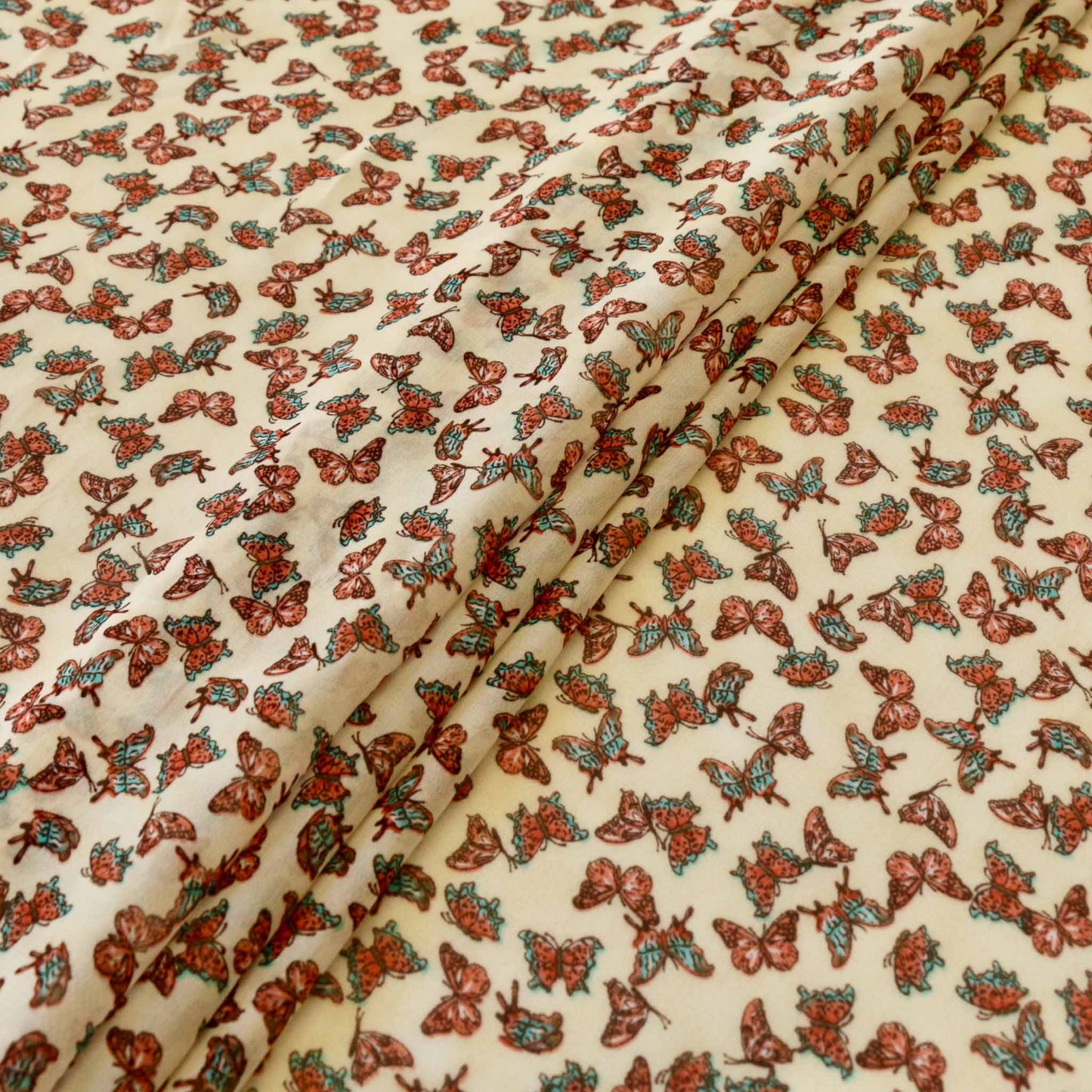 butterflies printed on pale beige chiffon polyester synthetic dressmaking fabric