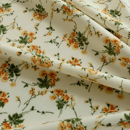 cream floral chiffon polyester dressmaking fabric with delicate orange and yellow flower print