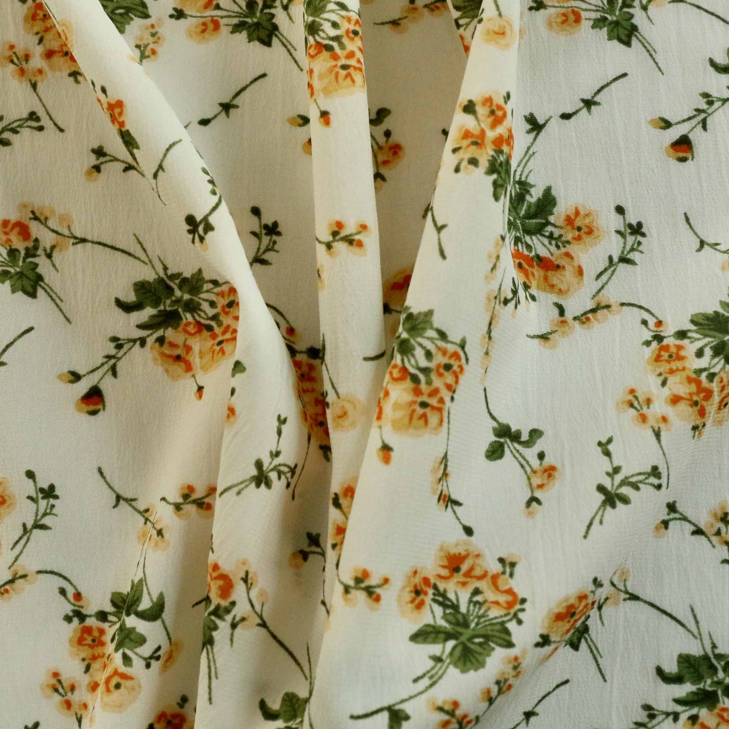 yellow and green flowers printed on cream chiffon polyester dressmaking fabric