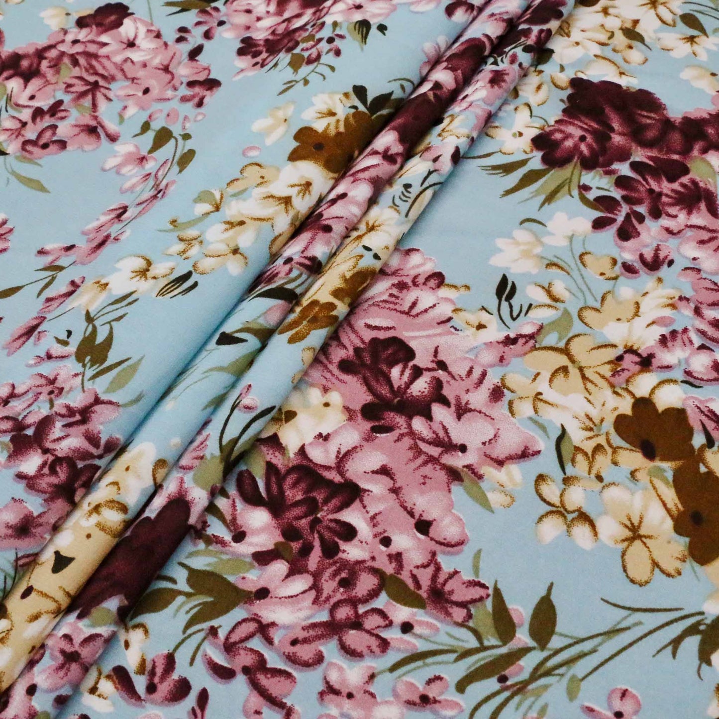 folded blue chiffon polyester dressmaking fabric with maroon and beige floral print