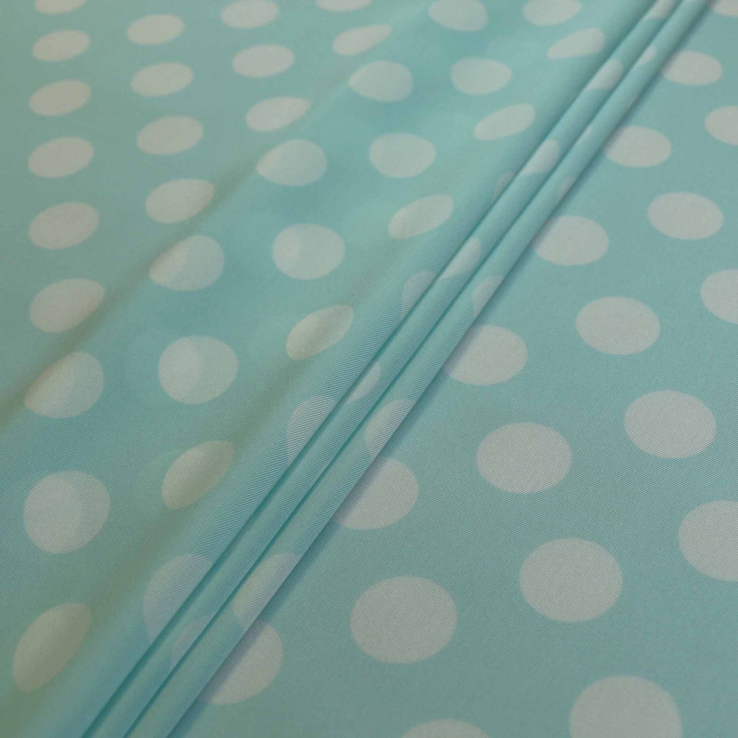 shiny satin dressmaking fabric in mint with white large polka dots