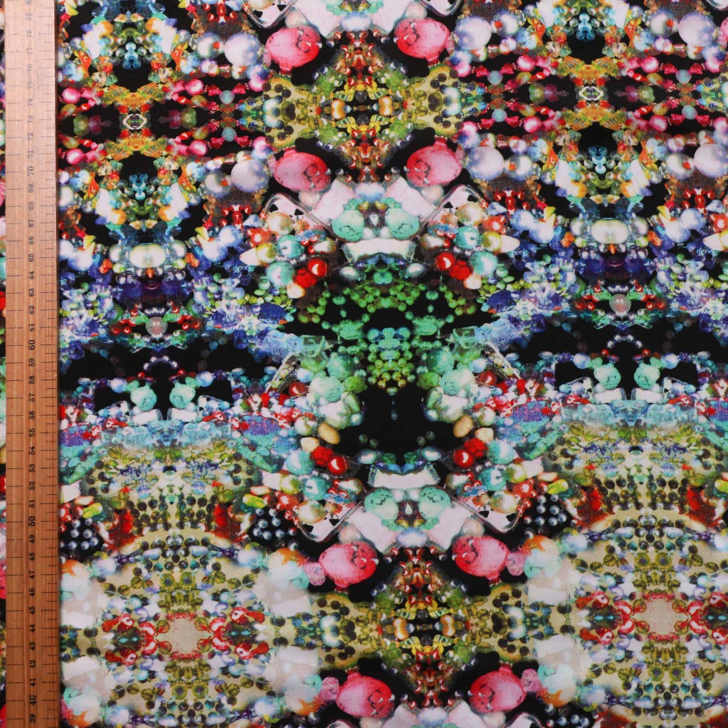 multicoloured jewellery on black viscose dressmaking fabric
