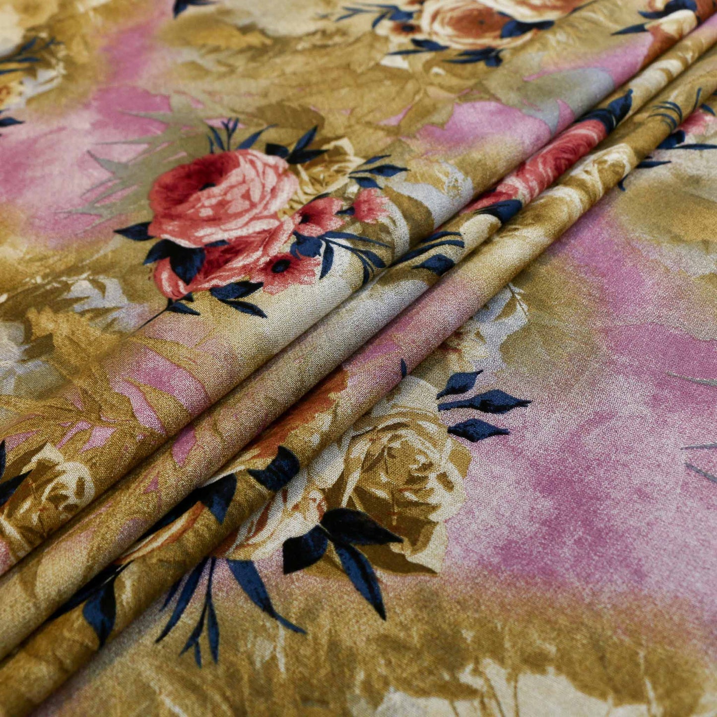 folded beige viscose challis dressmaking rayon fabric in mustard colour with pink and blue printed flowers