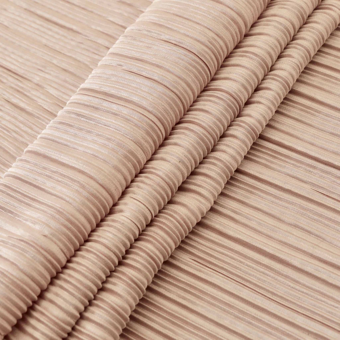 folded pink plisse dressmaking fabric with pleated striped wavy design