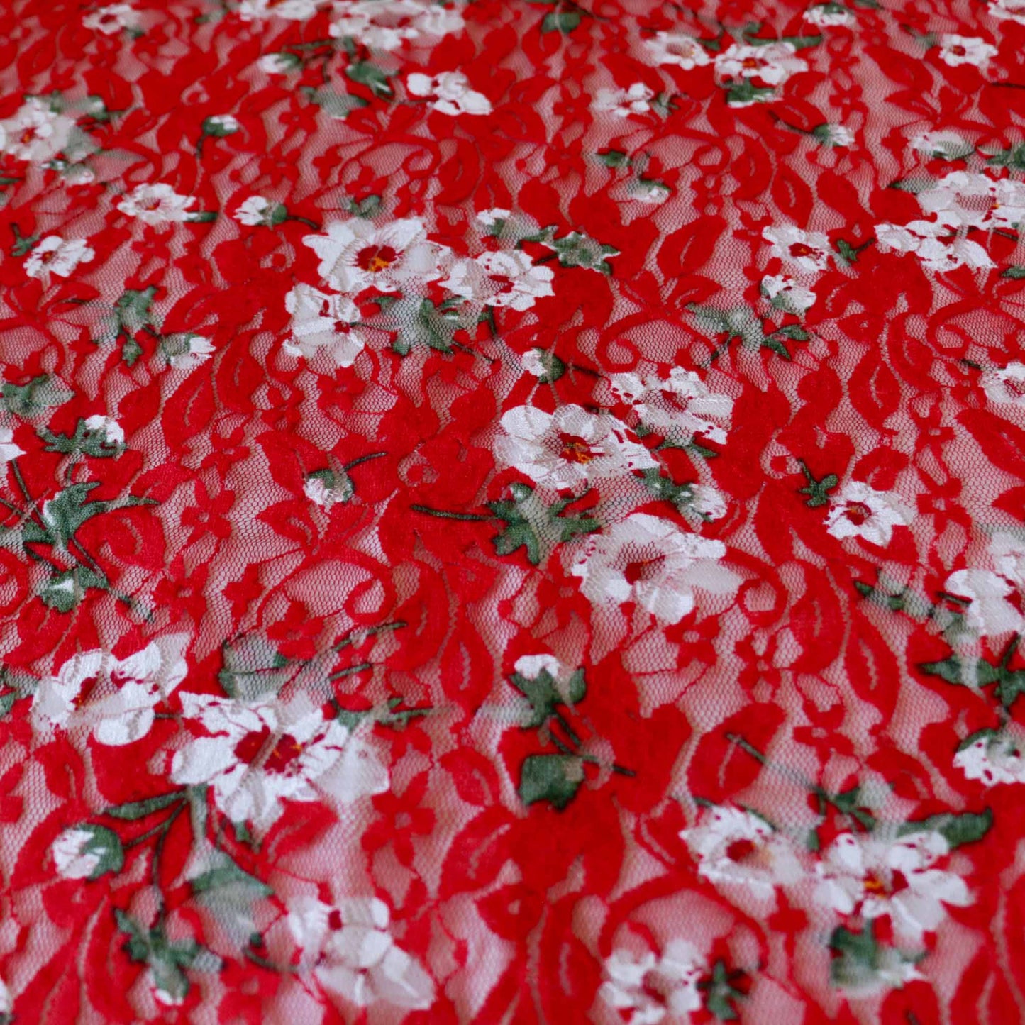 stretchy red lace dressmaking fabric with white floral design