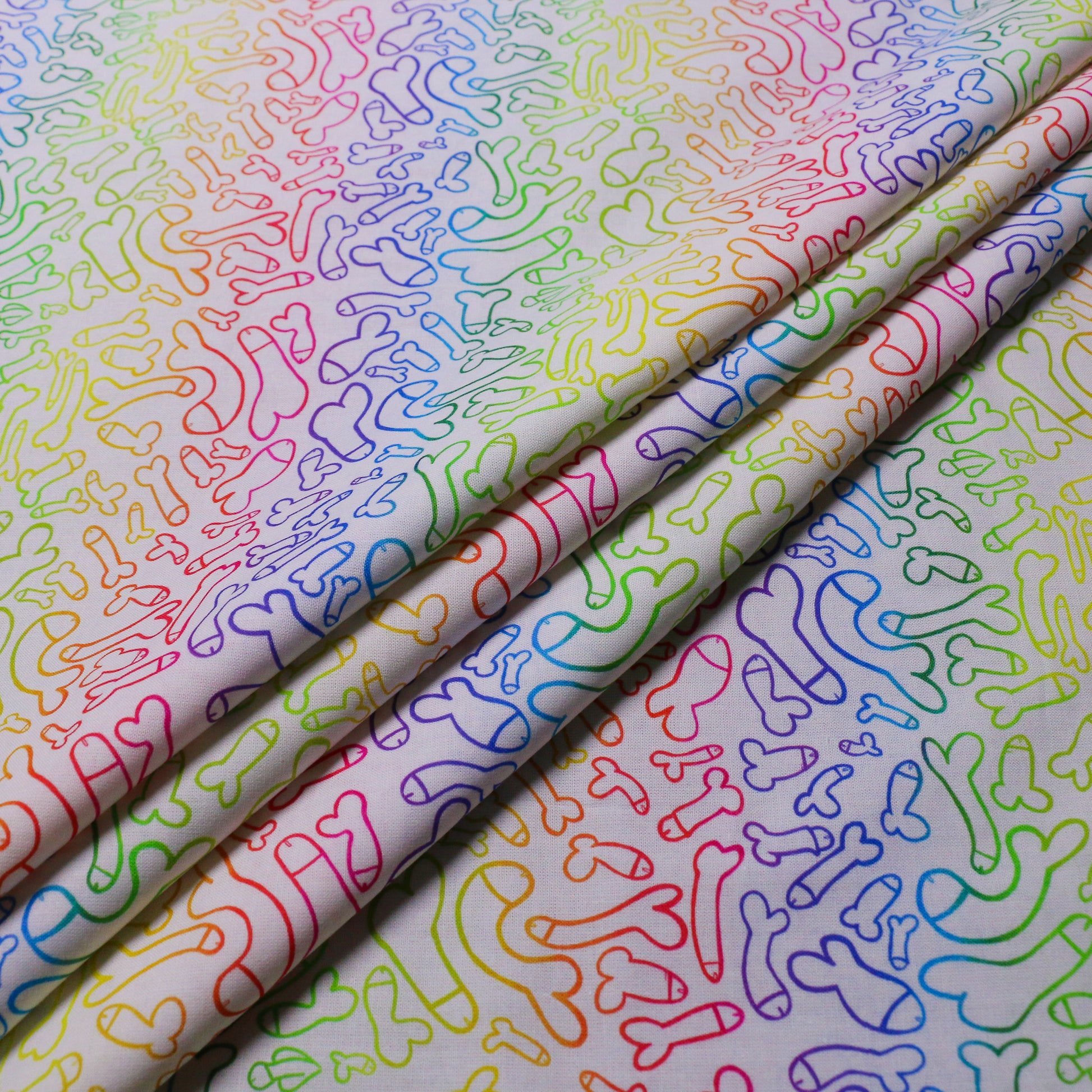 folded white pure cotton dressmaking fabric with multicoloured willy print