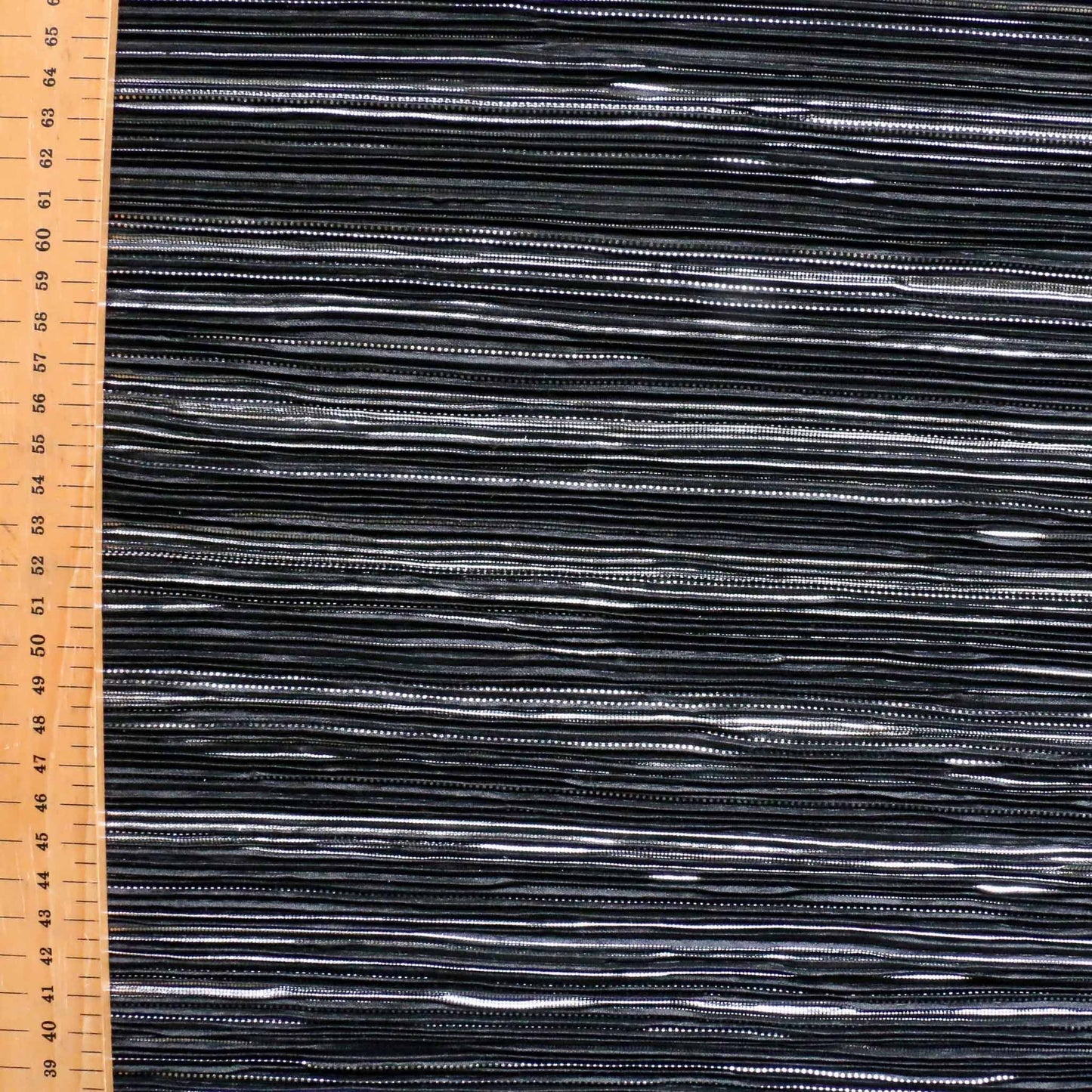 metre black pleated plisse dressmaking fabric with silver pattern design