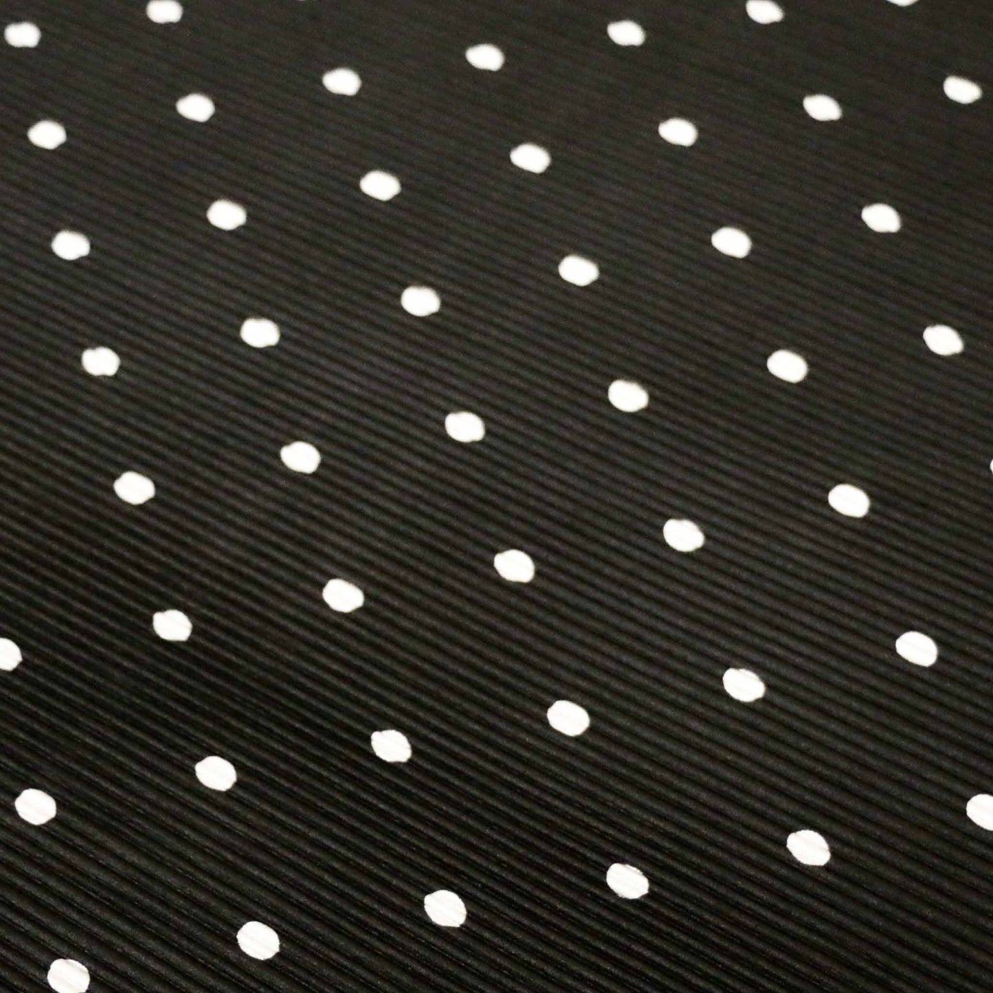 white polka dot on black stretchy plisse dressmaking fabric