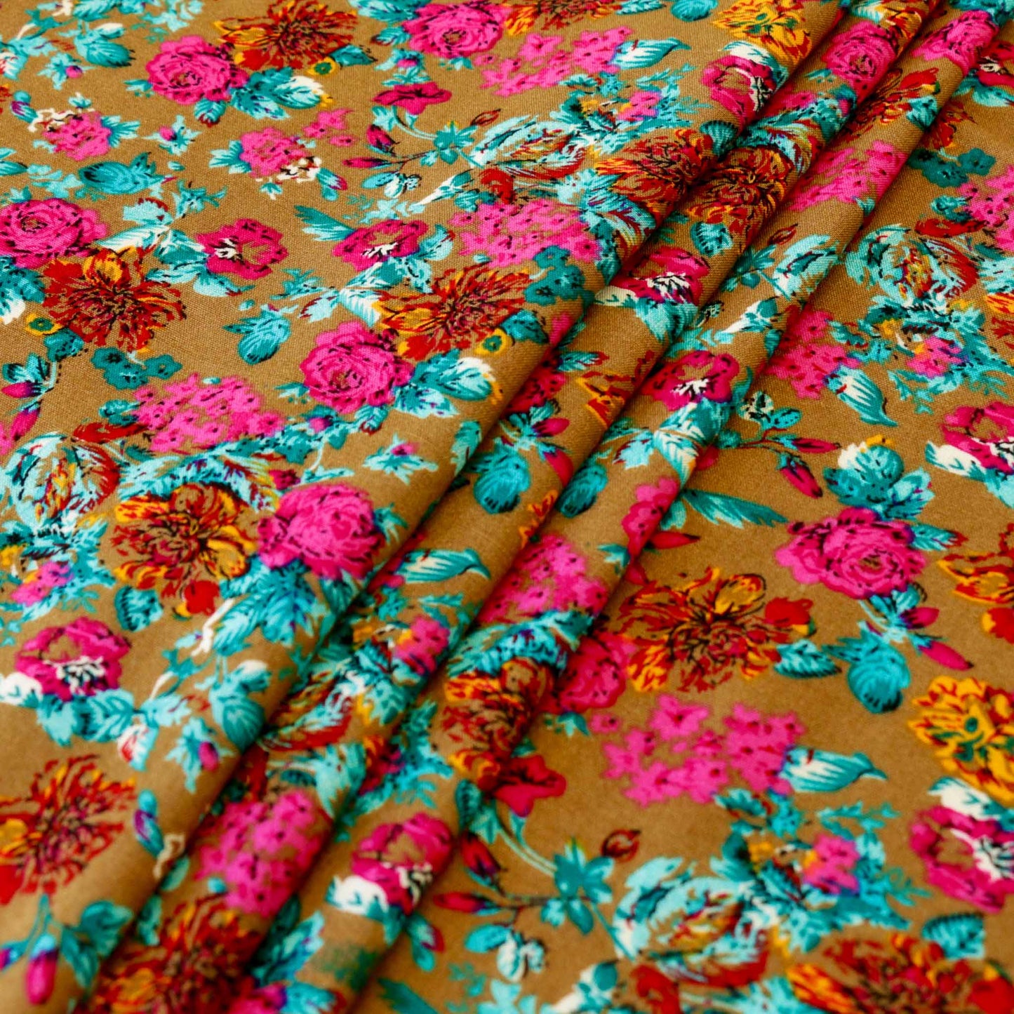 folded beige viscose rayon challis dressmaking fabric with pink and blue floral print