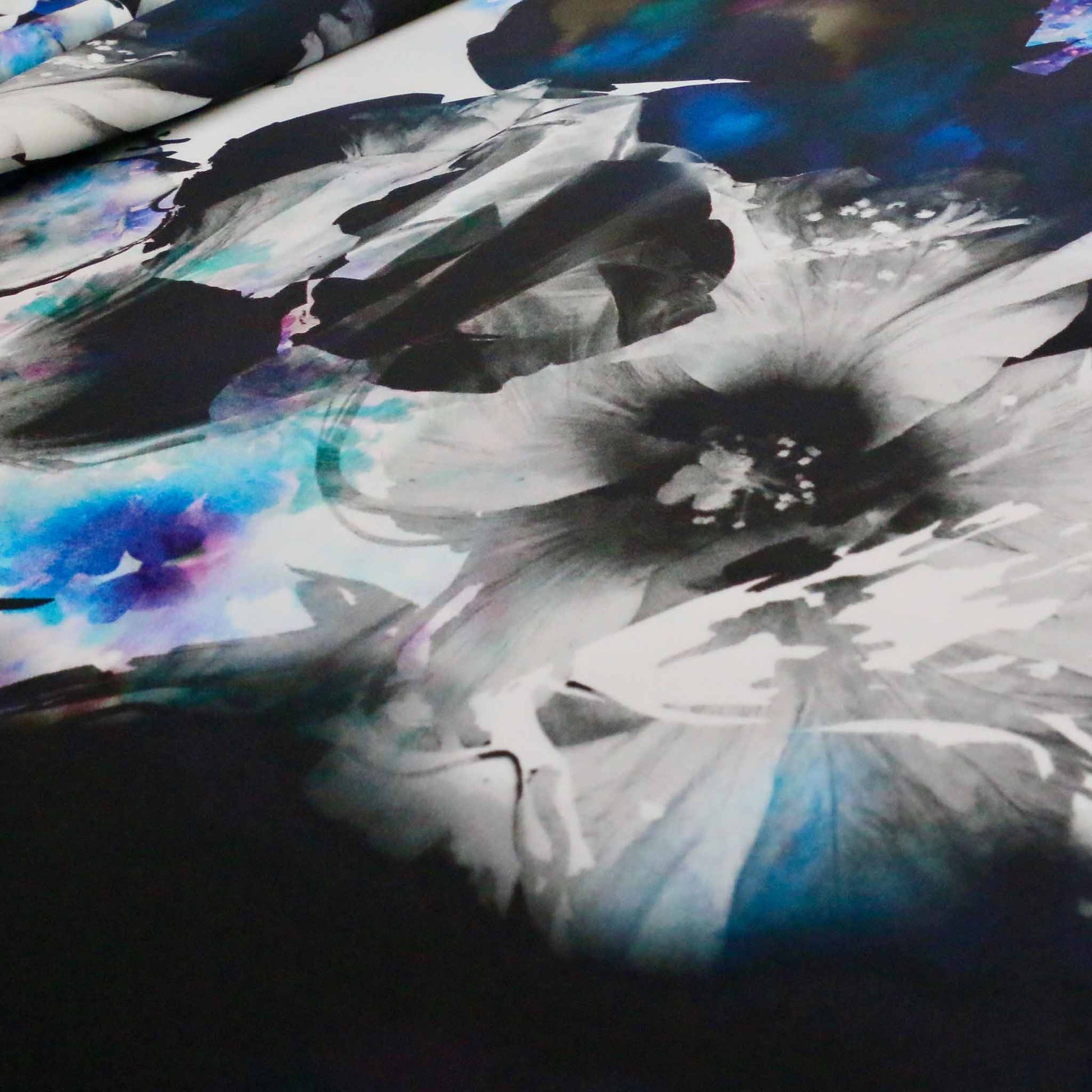abstract floral design in blue on black scuba jersey dressmaking fabric