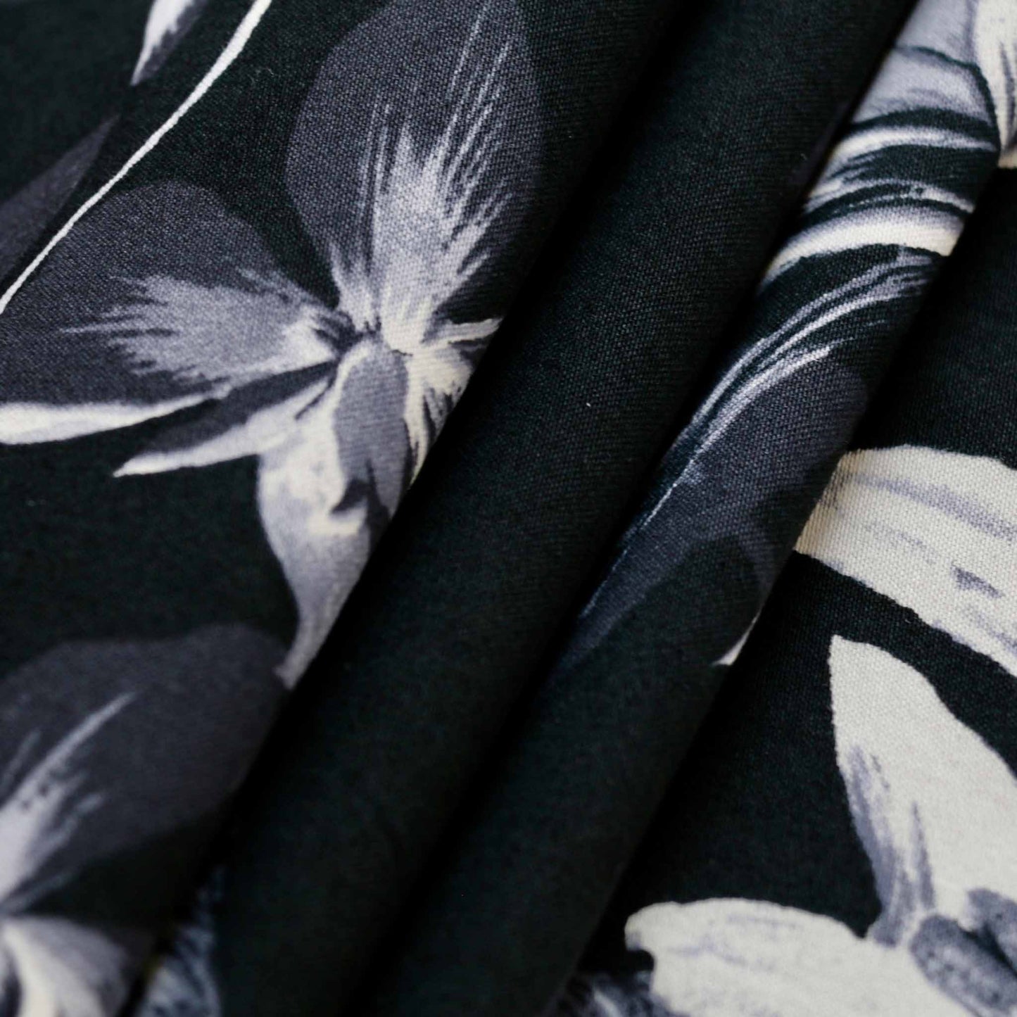 folded black cotton sateen fabric with large floral print in black