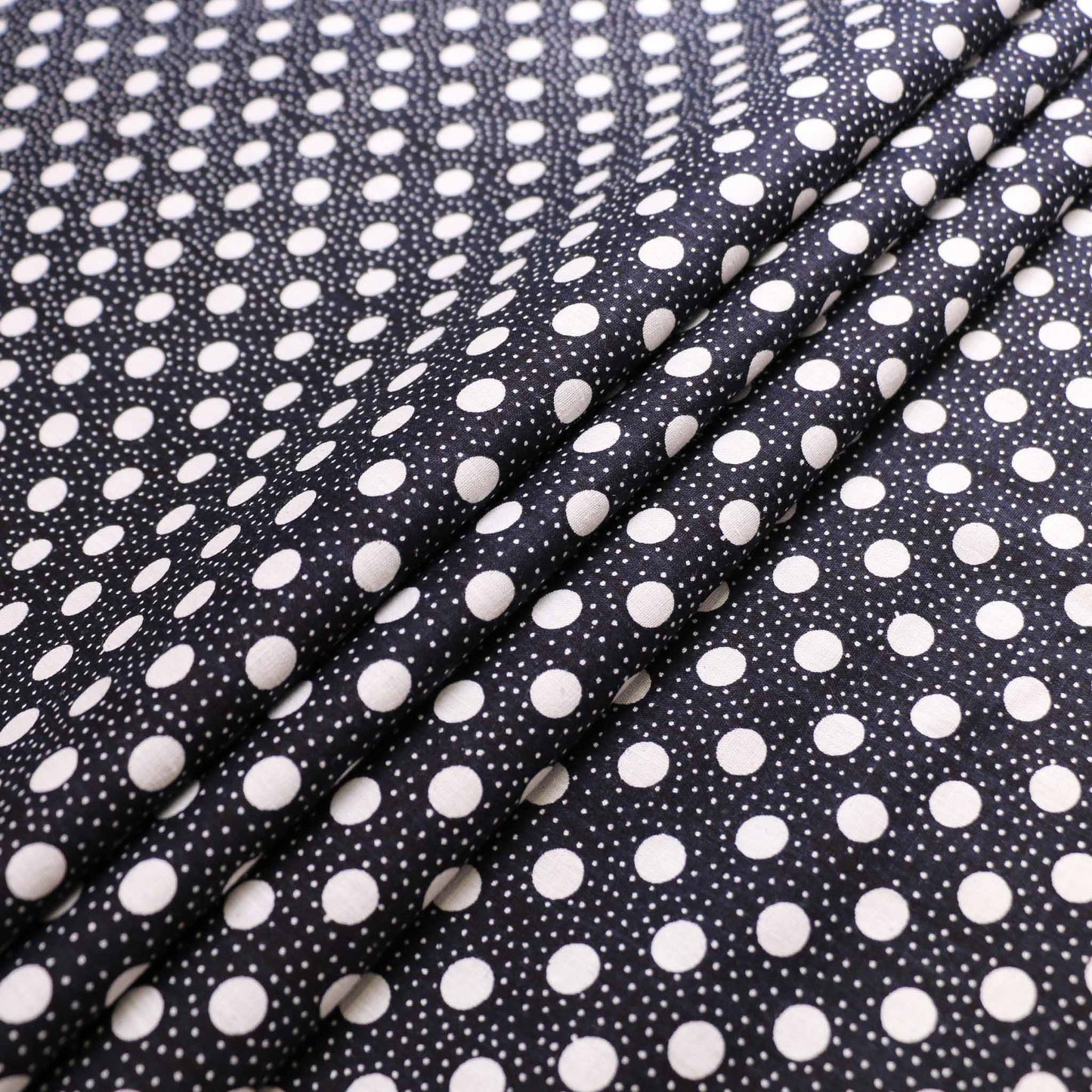 folded black vintage cotton poplin deadstock sustainable fabric with printed polka dot pattern