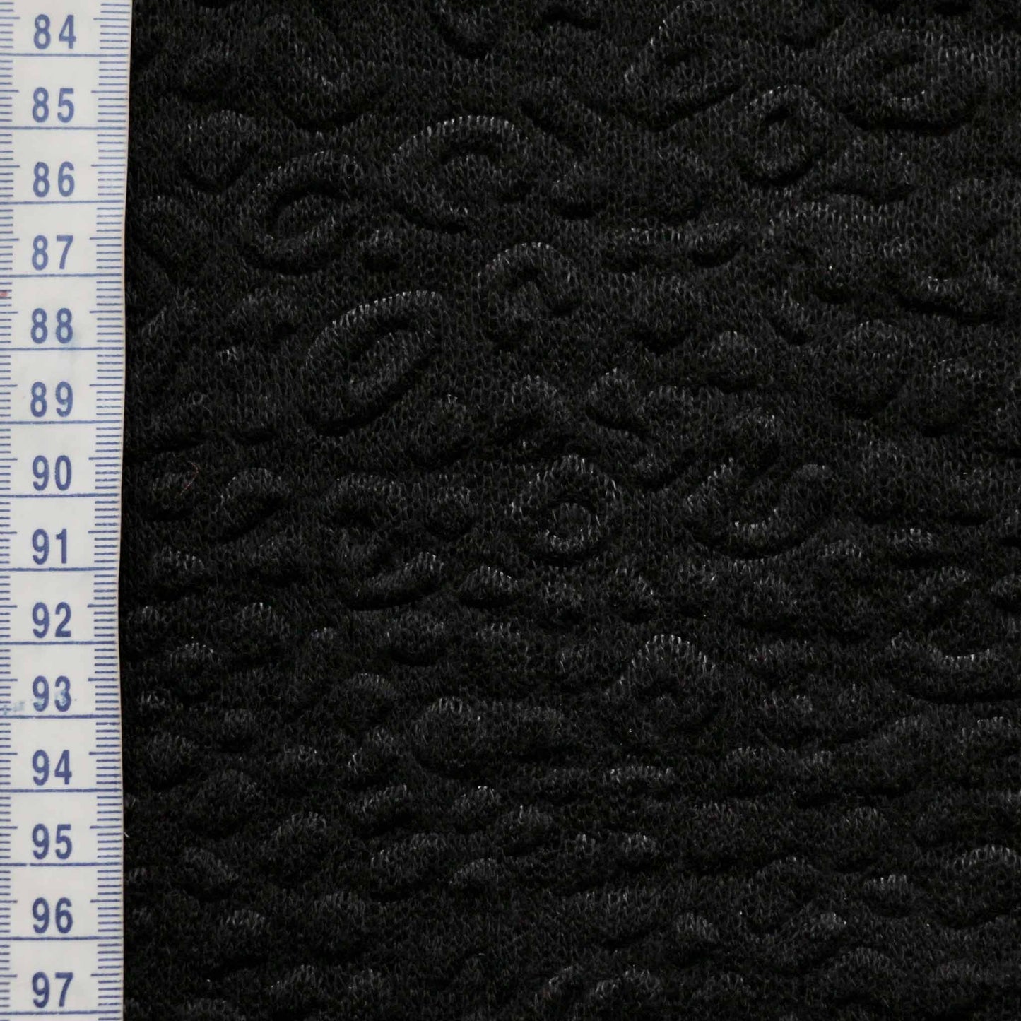 metre black jersey knit dressmaking fabric with decorative embossed texture