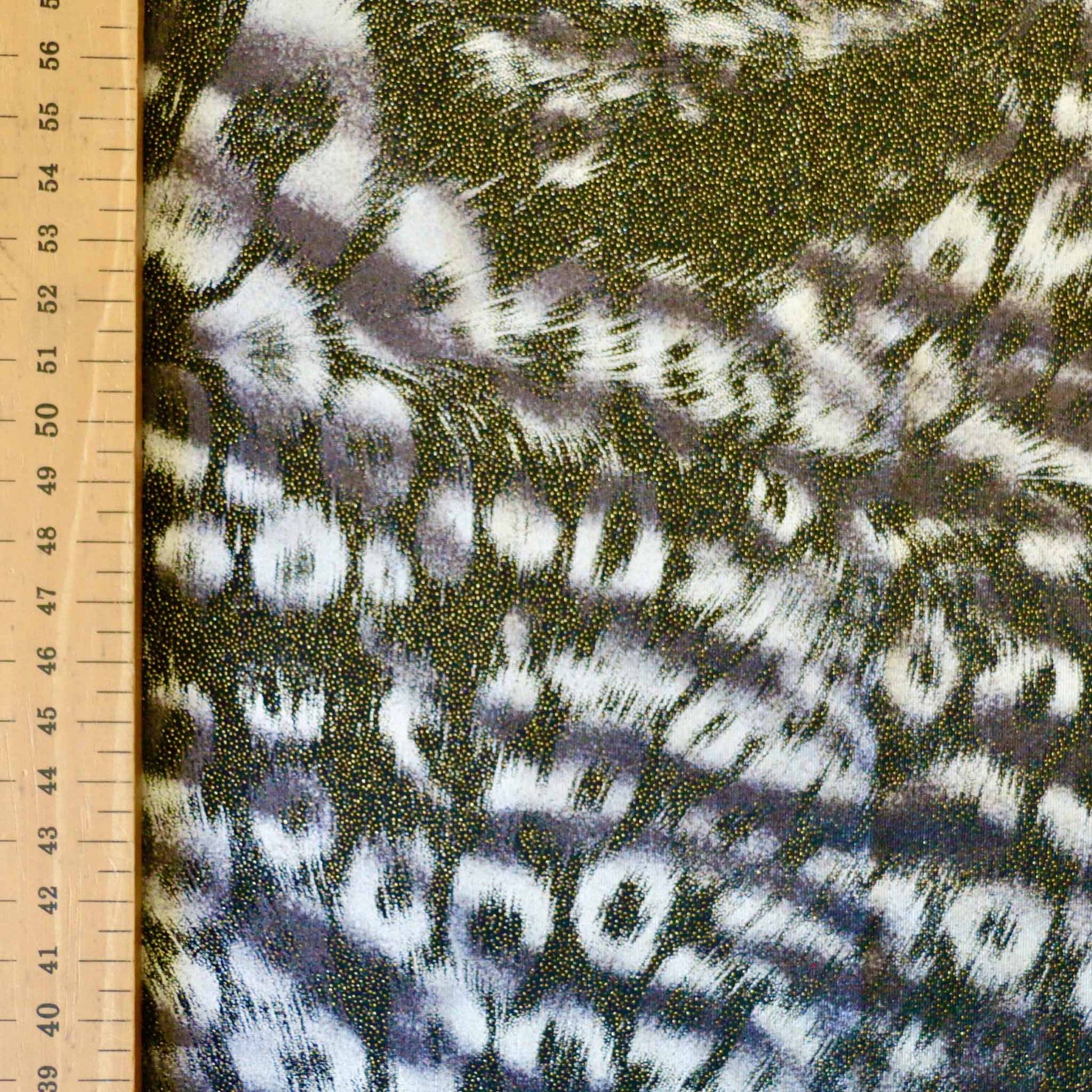 metre lycra dressmaking fabric with animal skin print design in black and shiny shimmer gold