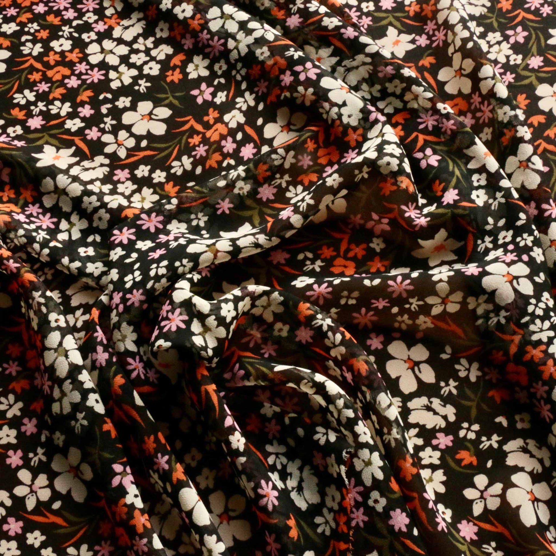orange and white floral printed flowers on black chiffon viscose dressmaking fabric