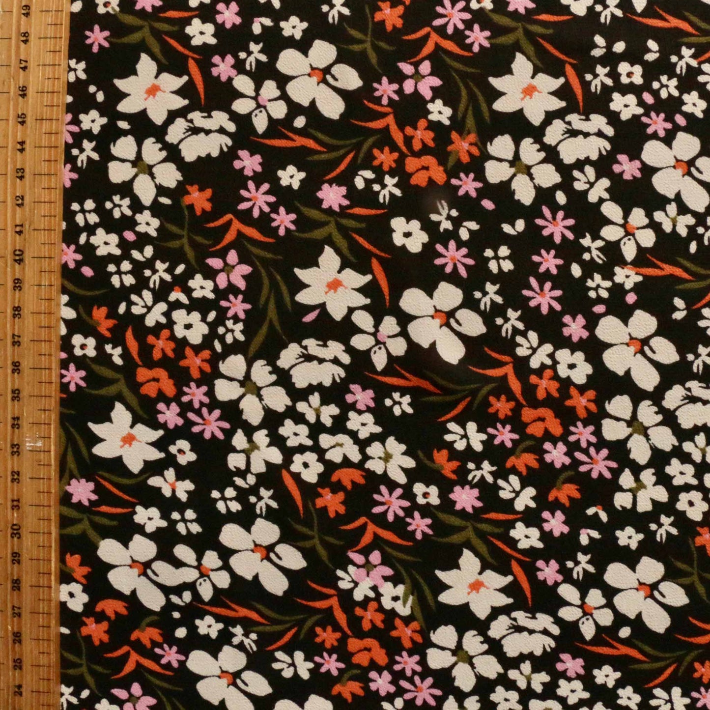 metre black viscose chiffon dressmaking fabric with white and orange floral print