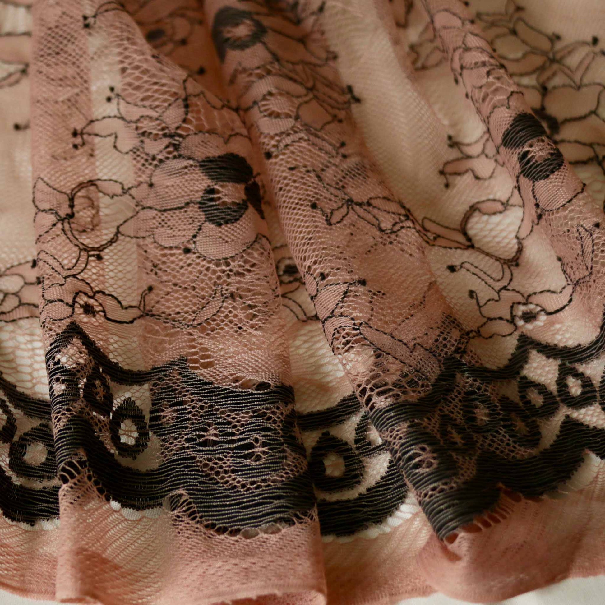 delicate black floral design on pale pink lace dressmaking nylon fabric