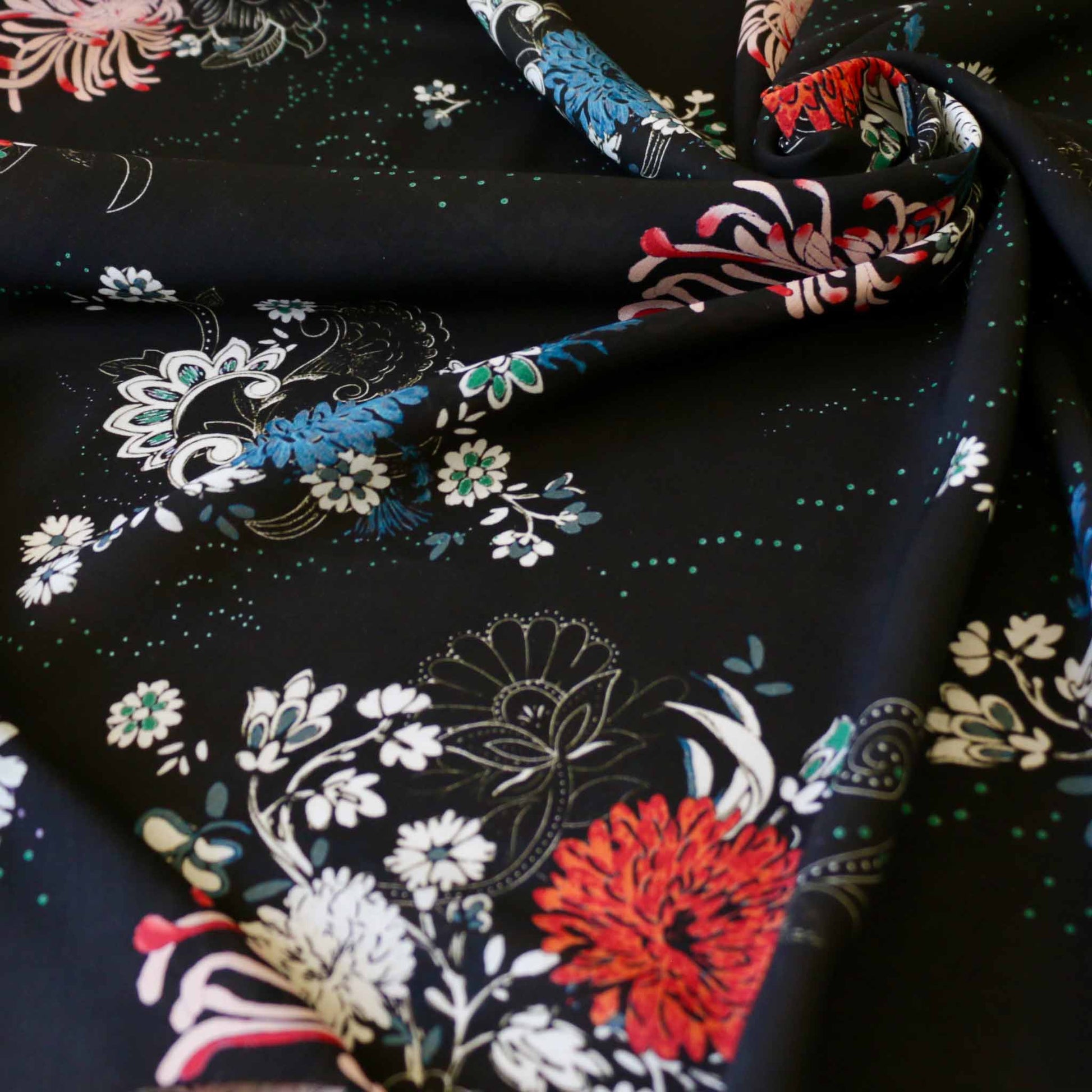 floral viscose rayon challis dressmaking fabric in black with red white and blue floral design