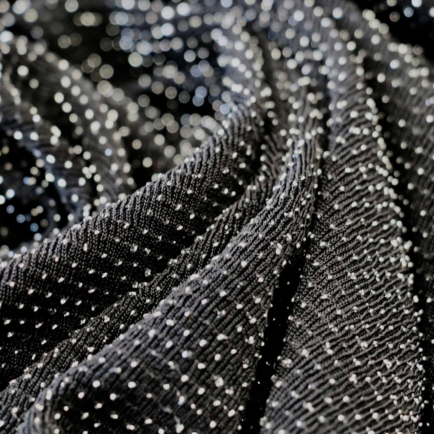 silver dots on black stretchy slinky jersey dressmaking fabric