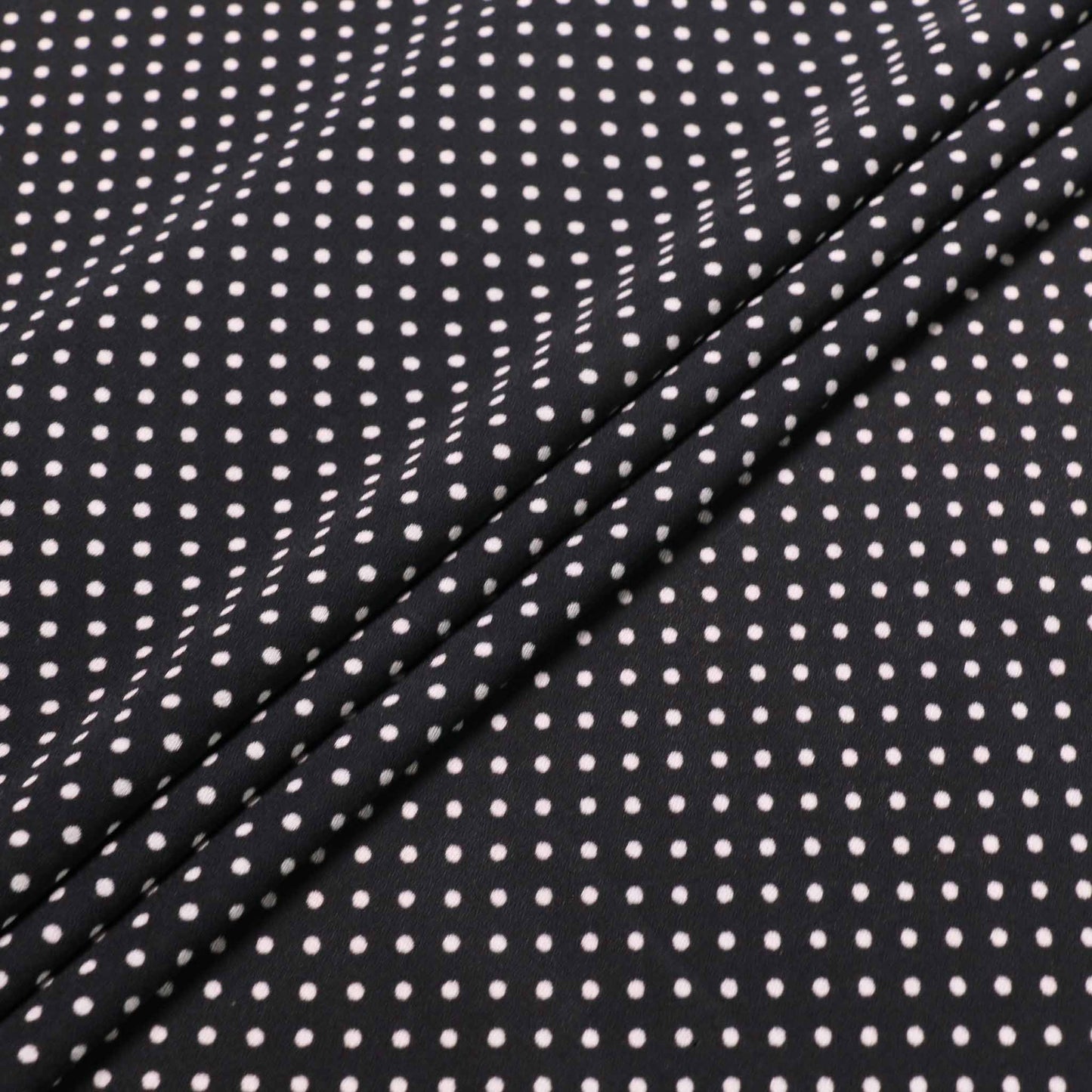 folded black and white polka dot fabric for dressmaking 