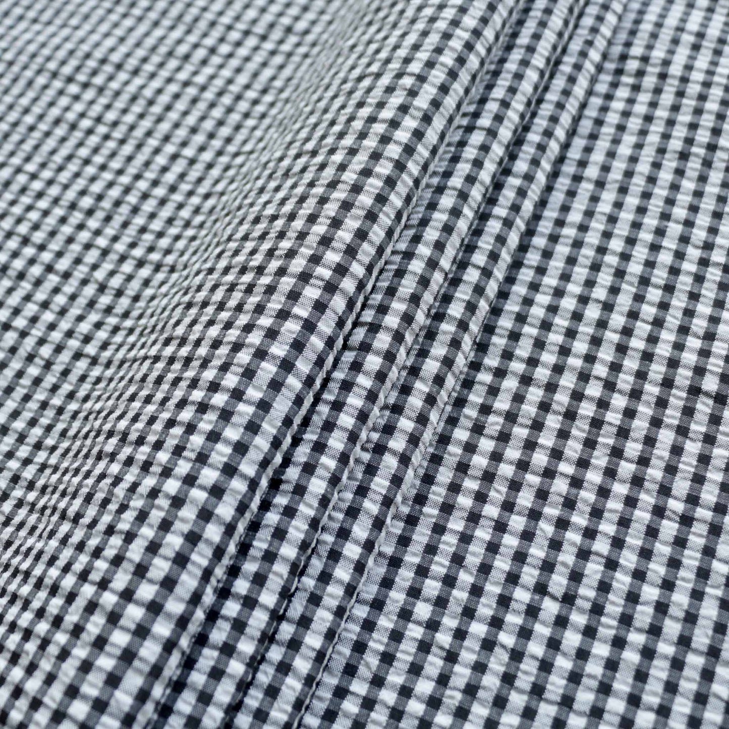 black and white folded seersucker dressmaking fabric in gingham print