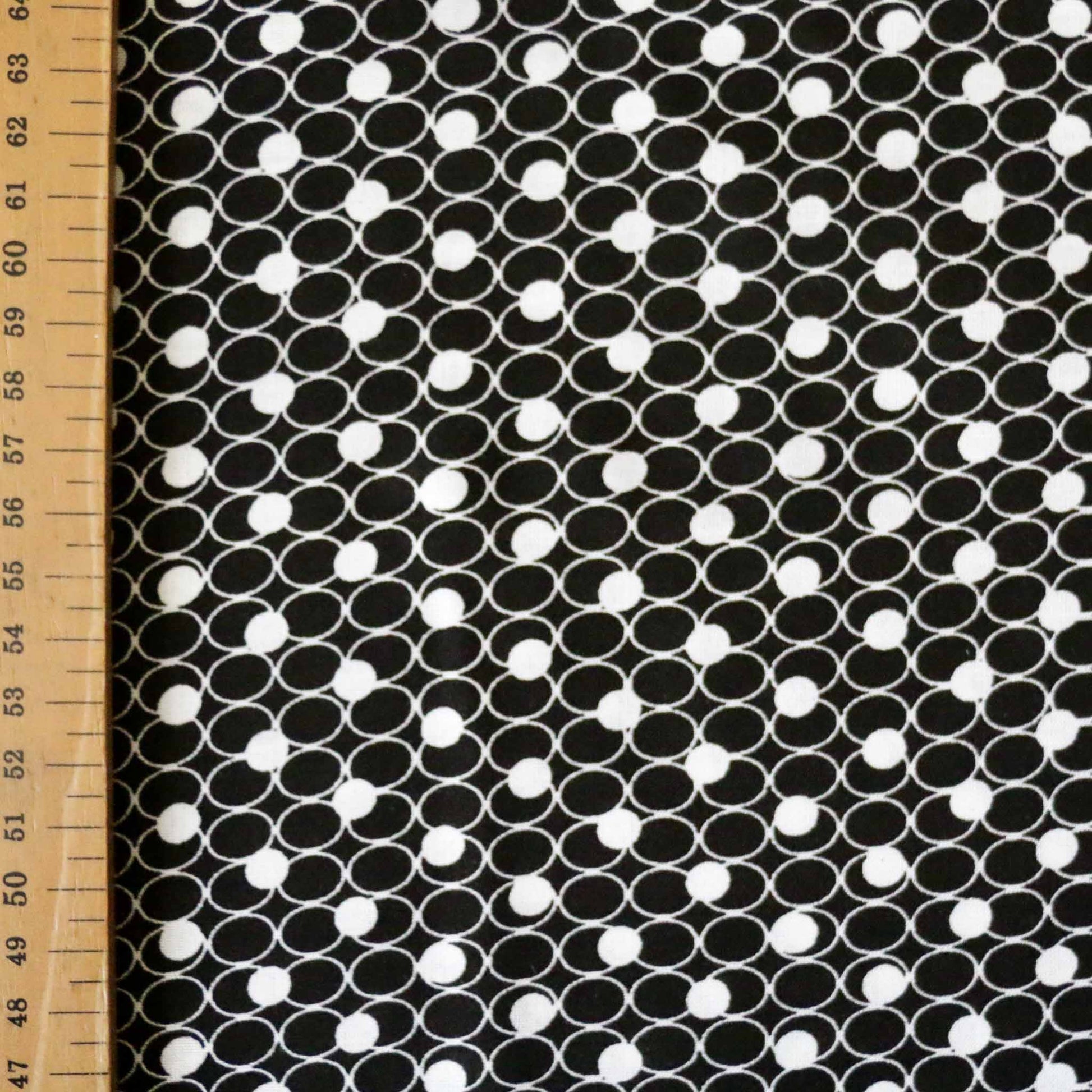 metre black viscose challis dressmaking fabric with white geometric circle printed design