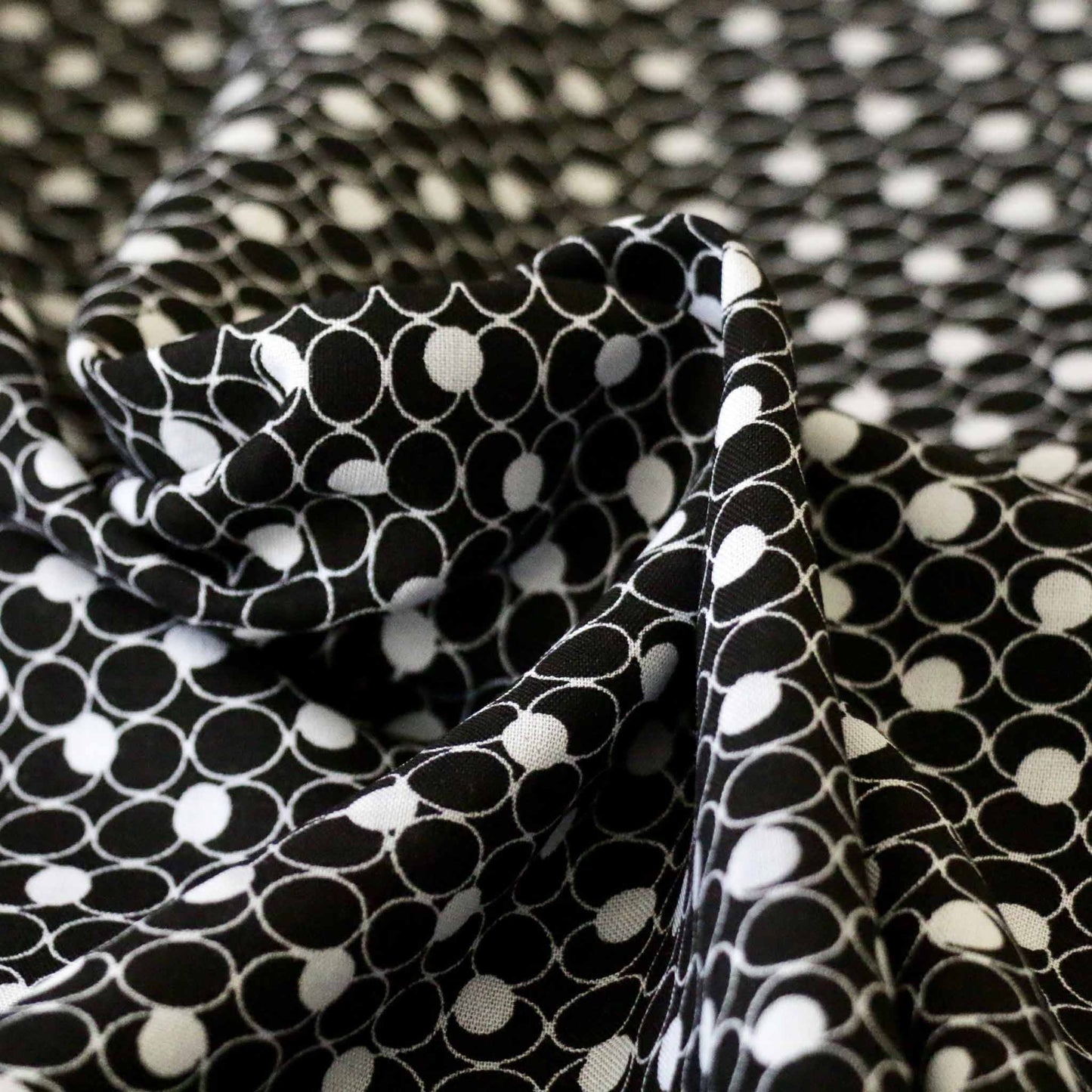 white circles printed on black viscose challis dressmaking rayon fabric
