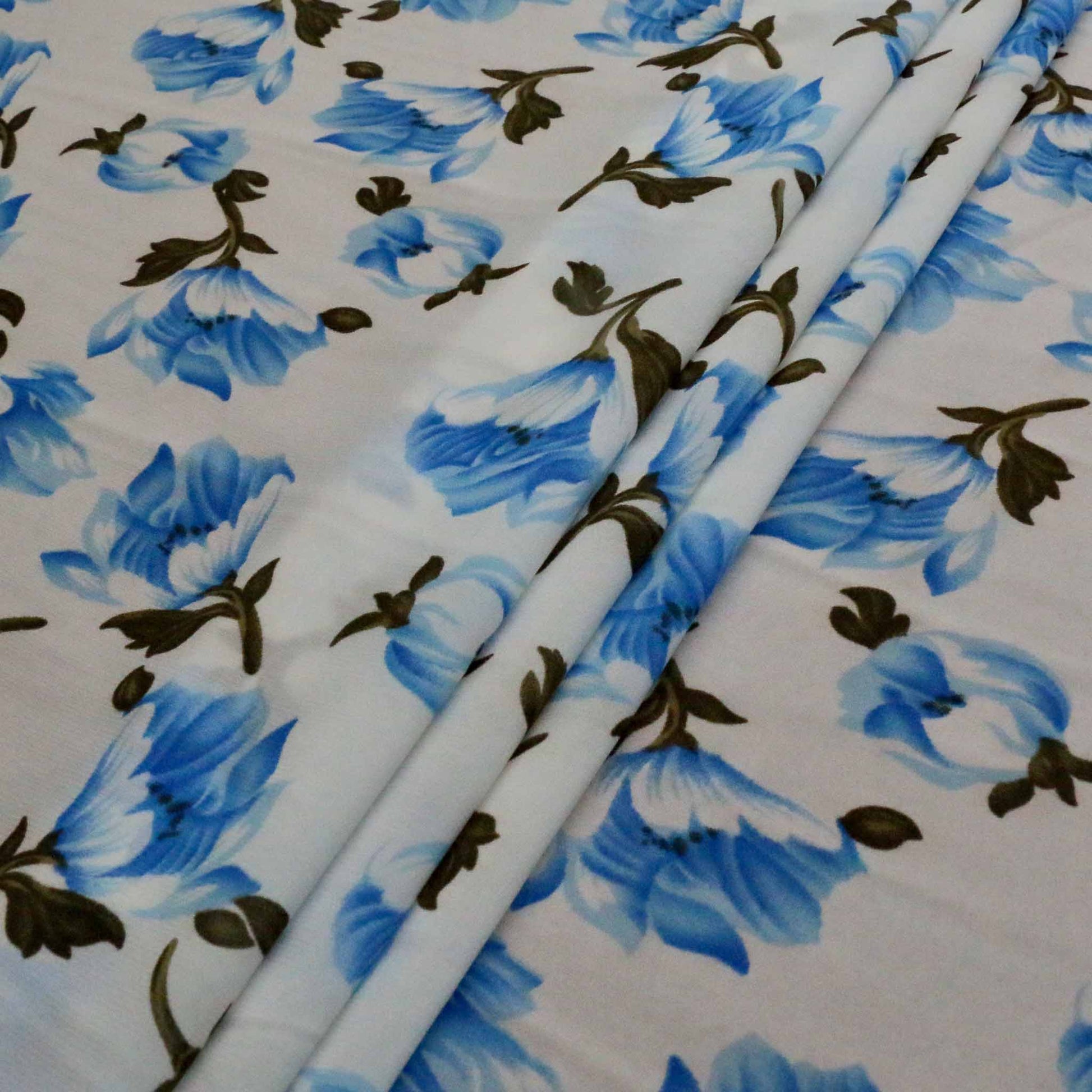folded white chiffon synthetic polyester dressmaking fabric with blue flower print