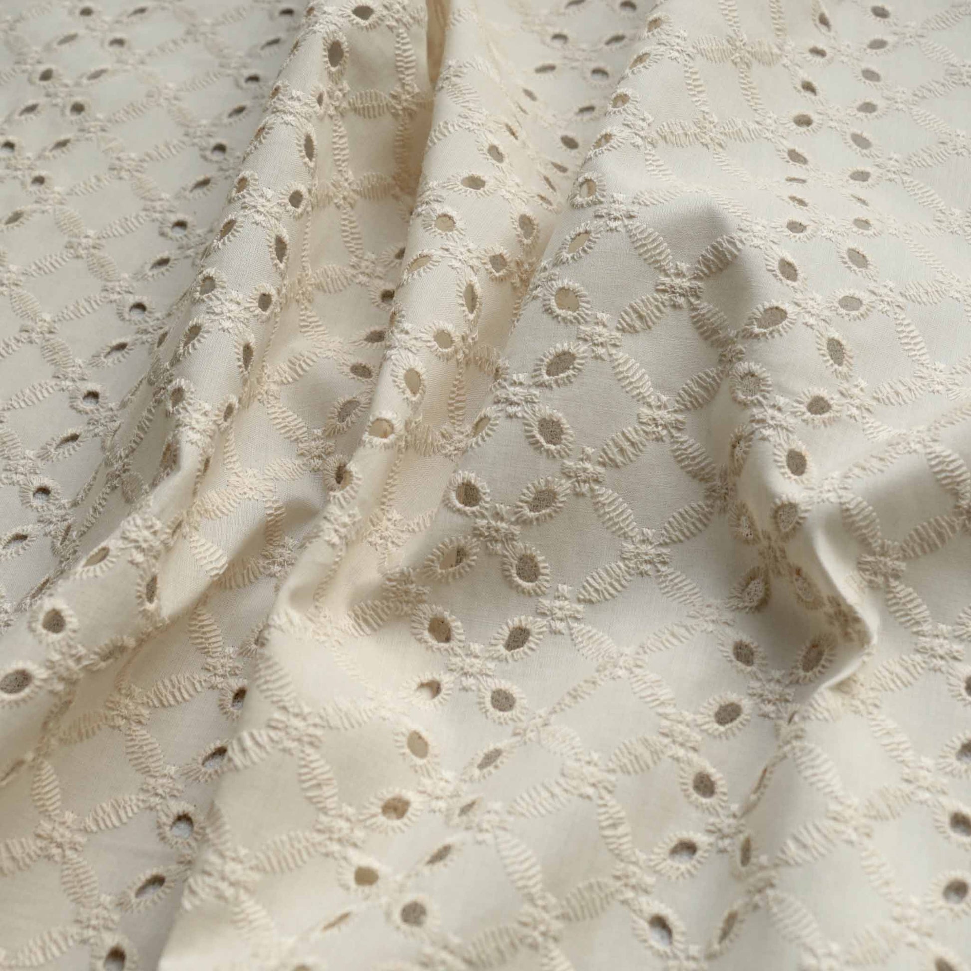 vintage look broad anglaise dressmaking fabric in ivory colour with 4 hole design