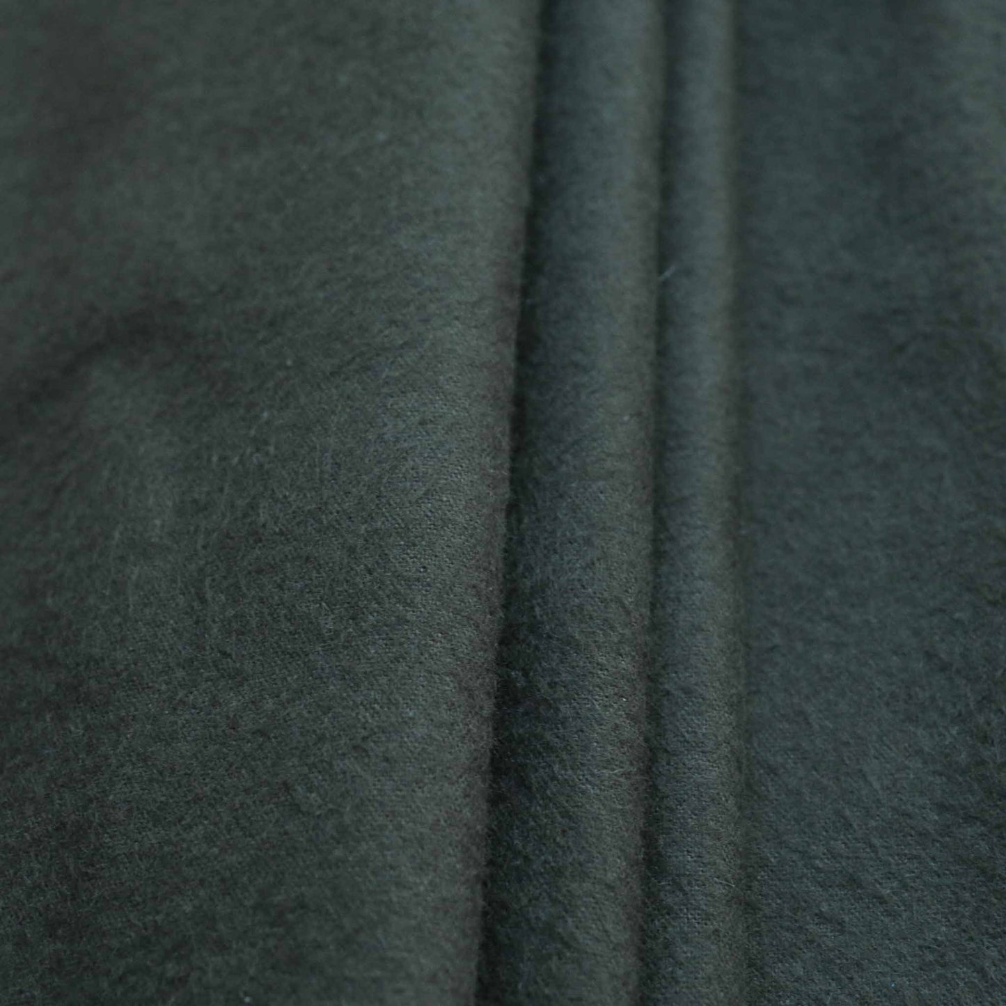 folded brushed cotton dressmaking fabric in dark green colour