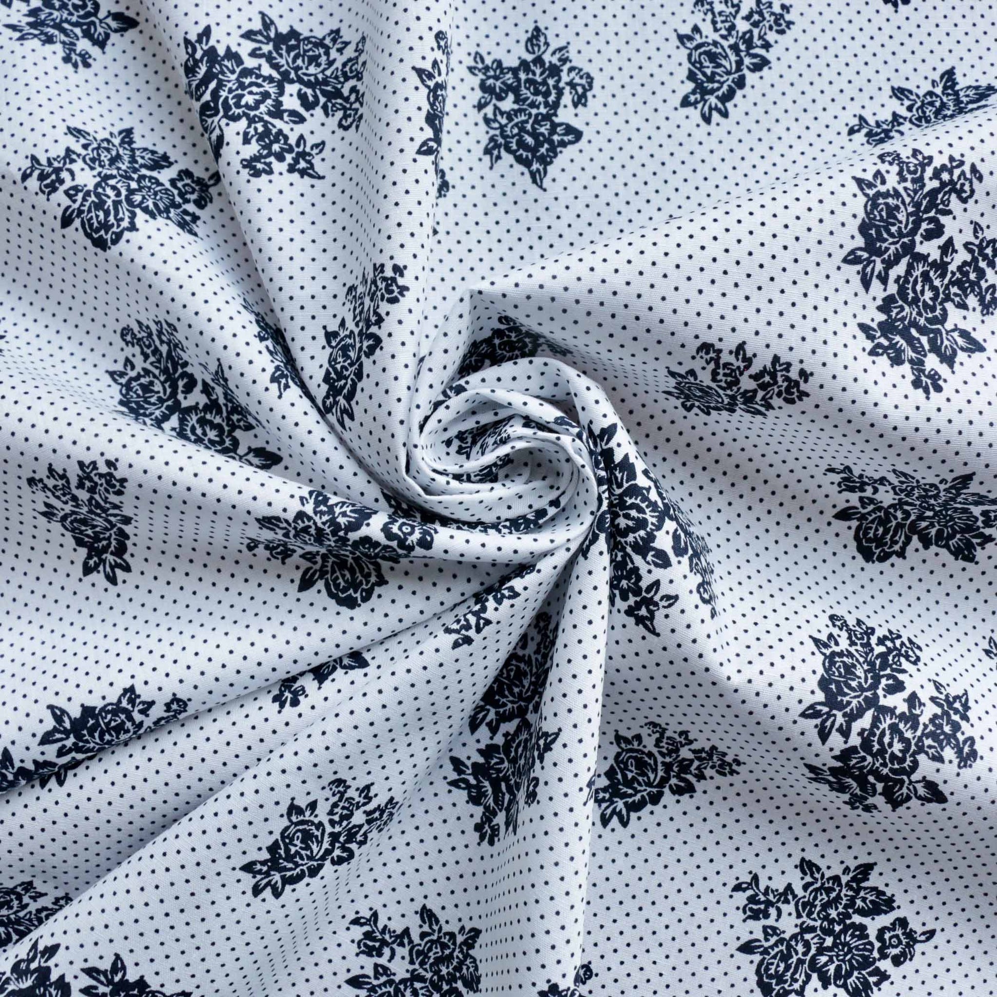 navy dots and flower design on white cotton dressmaking fabric