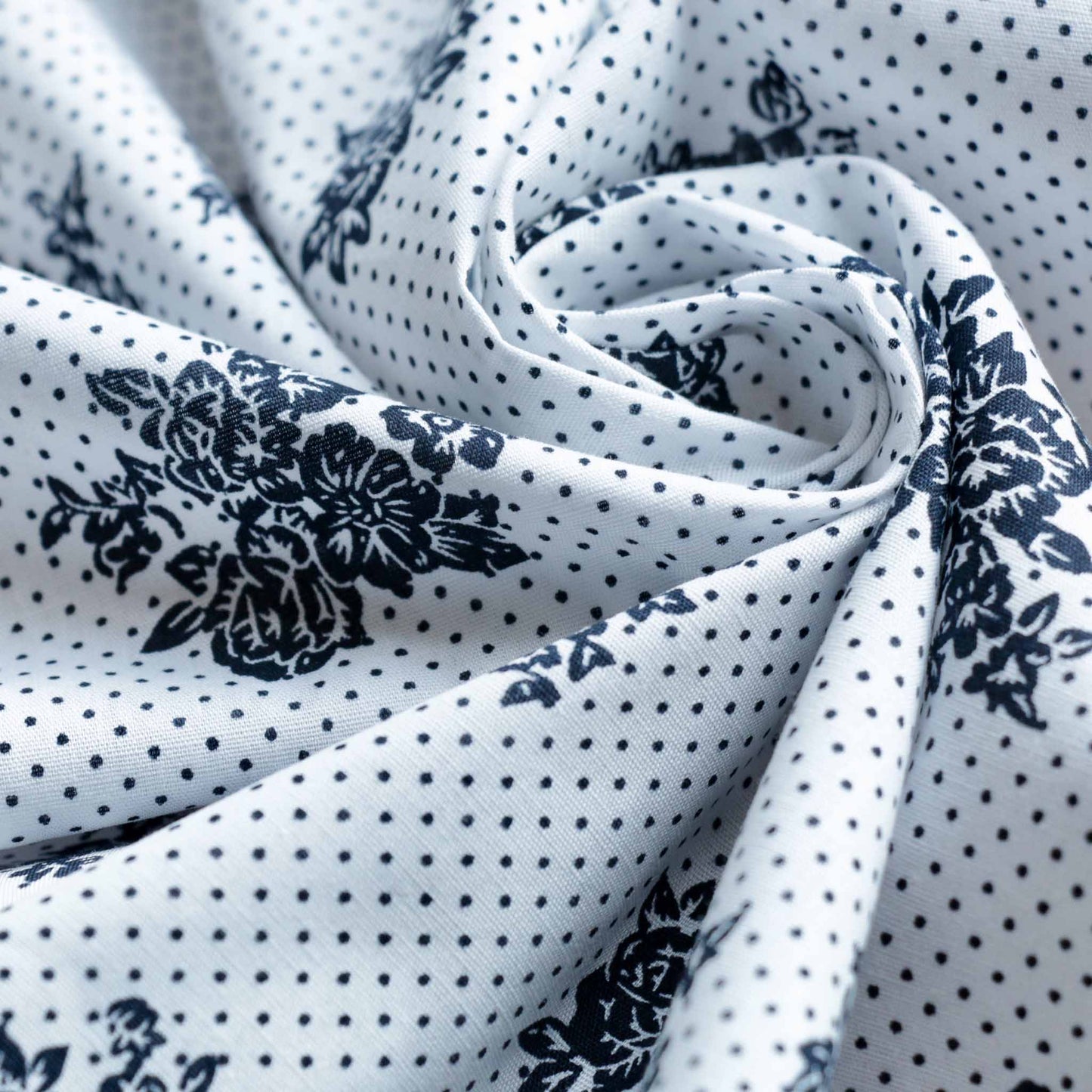 navy polka dot and flower design on white dressmaking cotton fabric