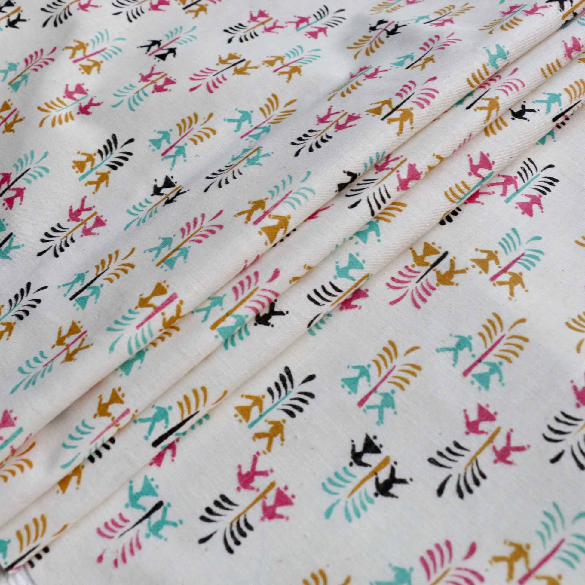 folded cream vintage dressmaking fabric for sustainable sewing printed with colourful boy girl pattern