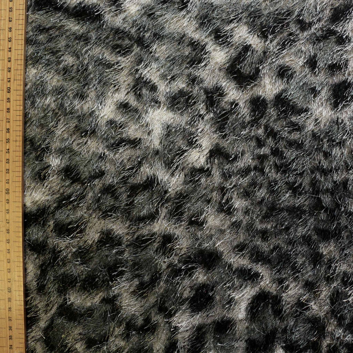 metre grey and black eyelash dressmaking fabric with silvery grey and black jaguar print animal skin pattern