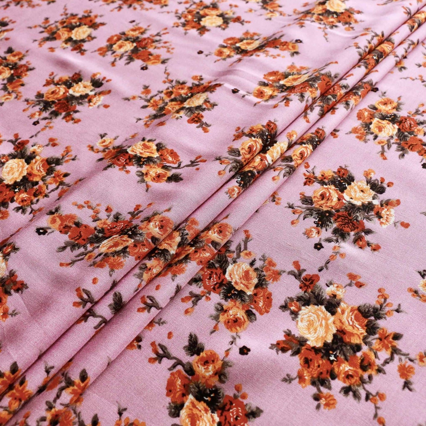 folded viscose challis dressmaking fabric in lilac yellow and orange with printed flower pattern