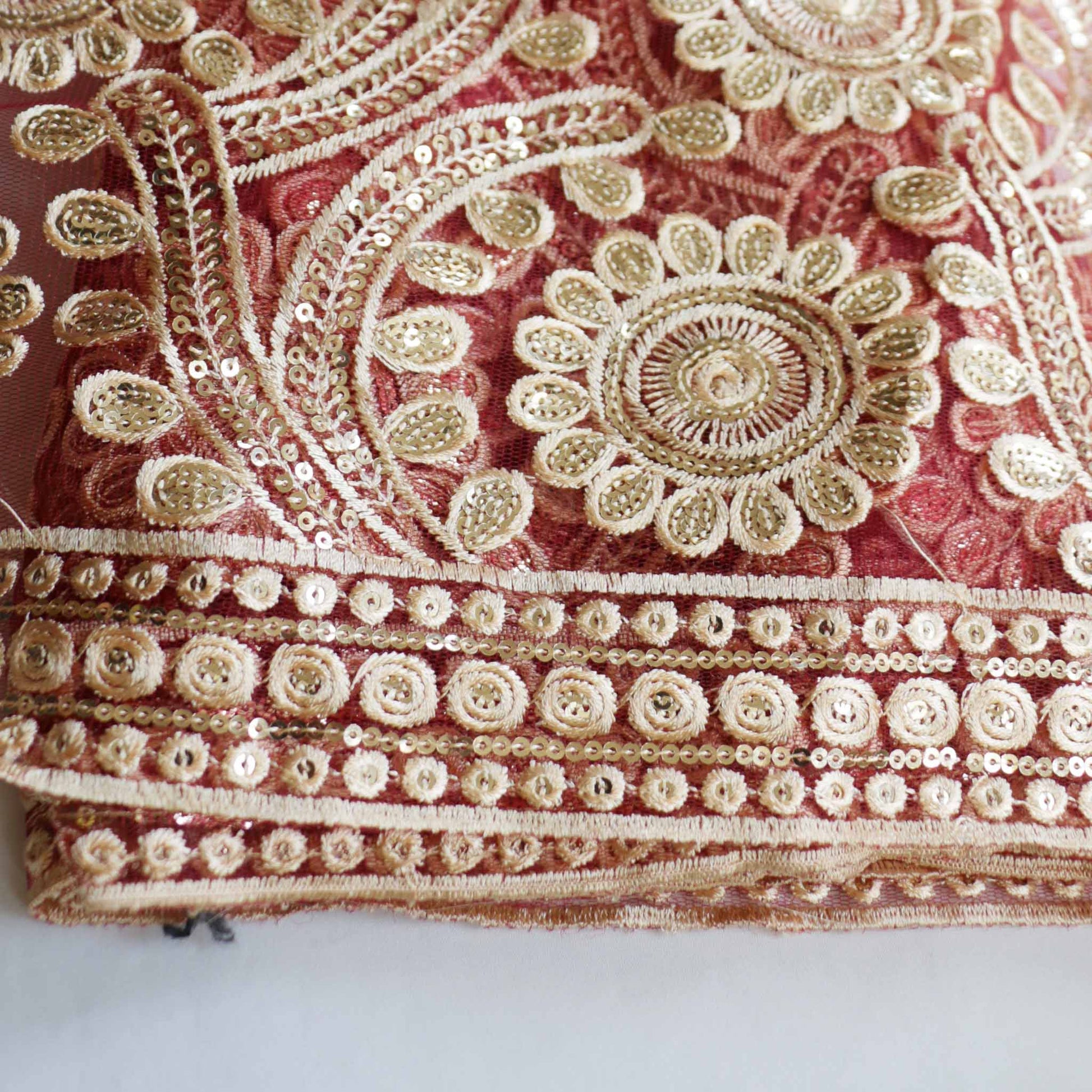maroon tulle dressmaking fabric with heavy elaborate gold embroidery
