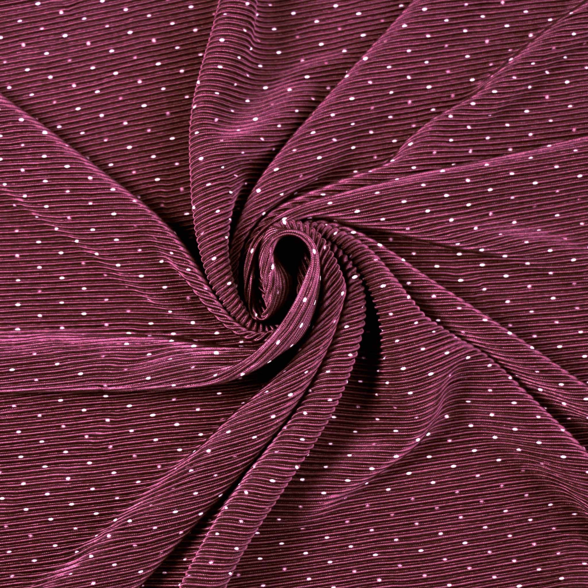 pleated maroon plisse dressmaking fabric with white polk dot design on shimmer effect texture
