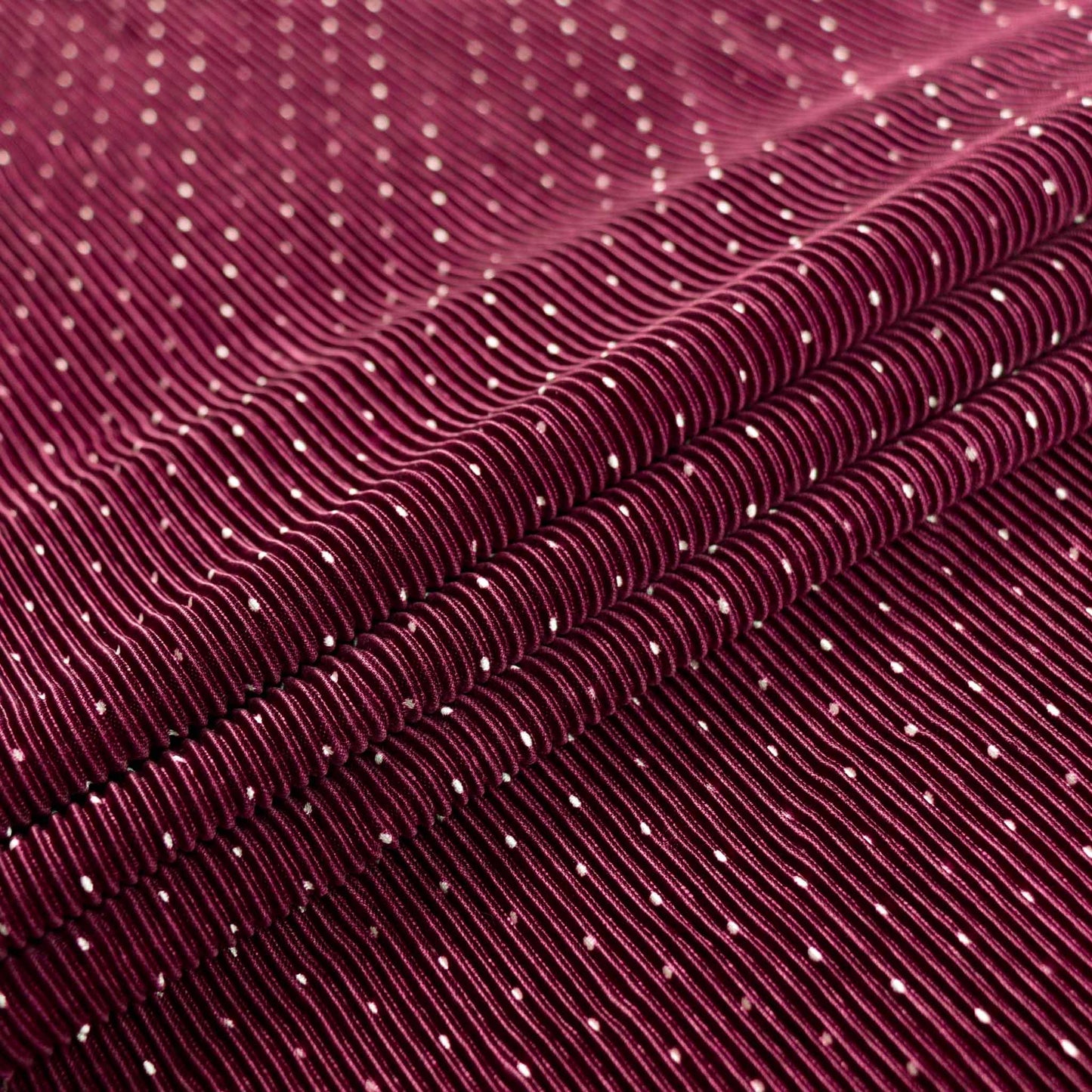 shimmer effect maroon pleated plisse dressmaking fabric with white polka dot pattern