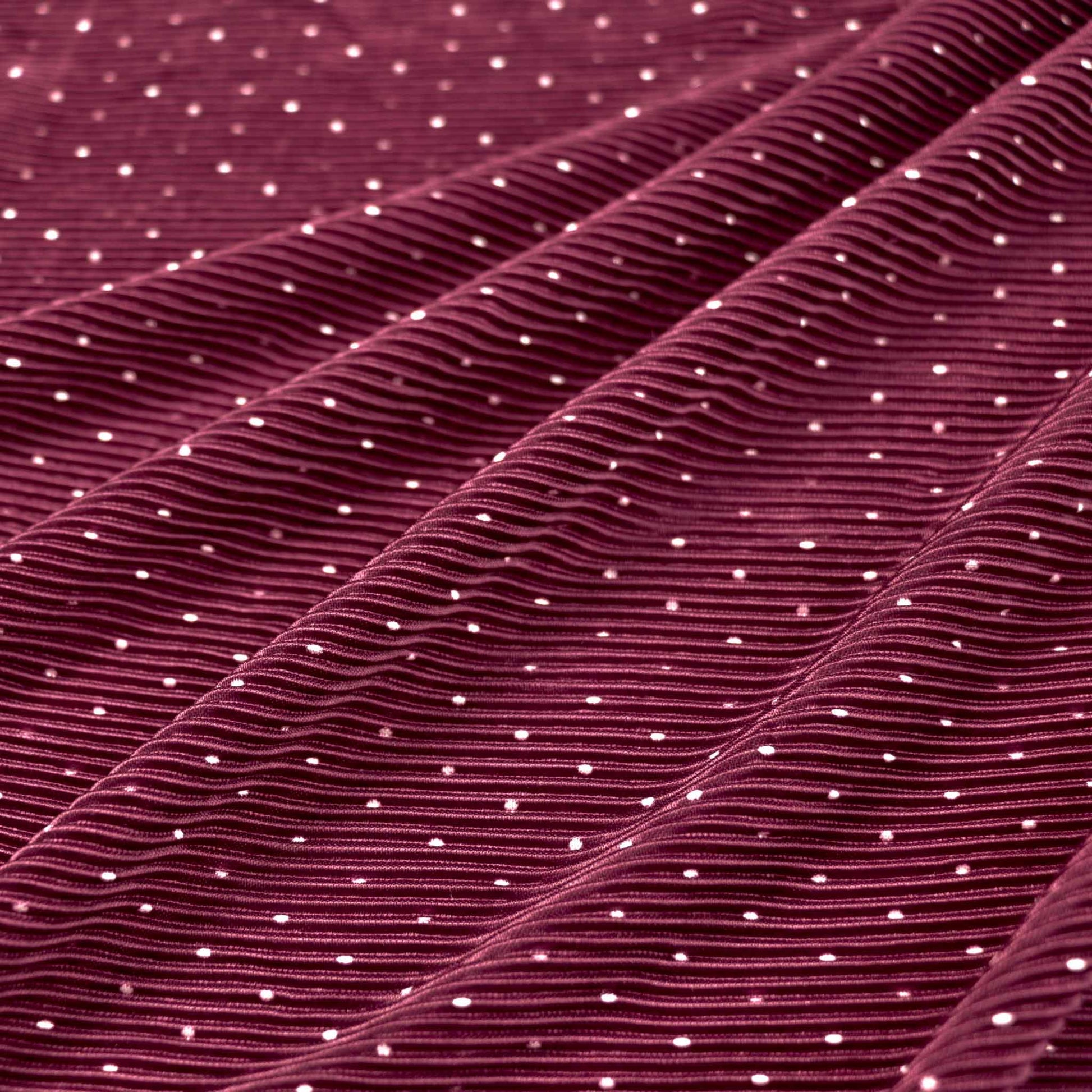 shimmer maroon plisse dressmaking fabric with pleated texture and white polka dot design