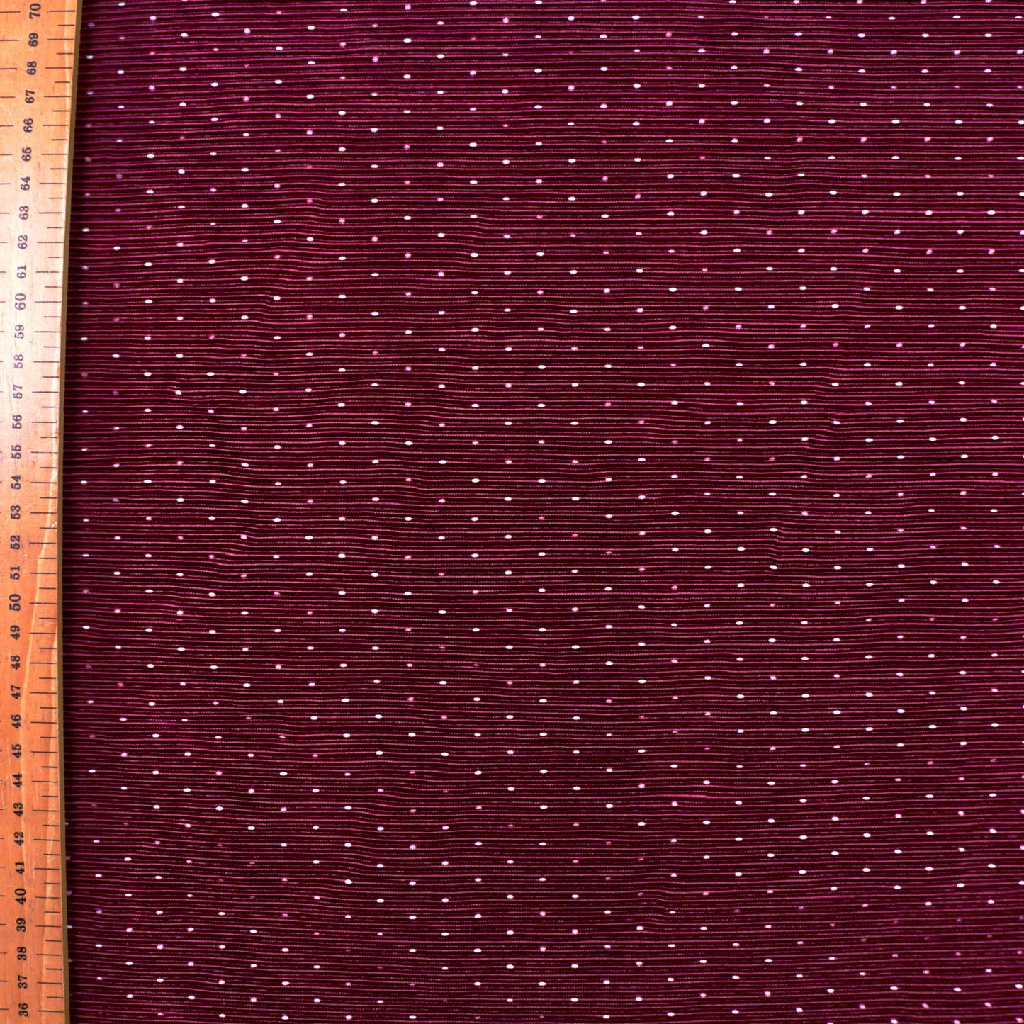 metre white polka dot design on maroon pleated plisse dressmaking fabric