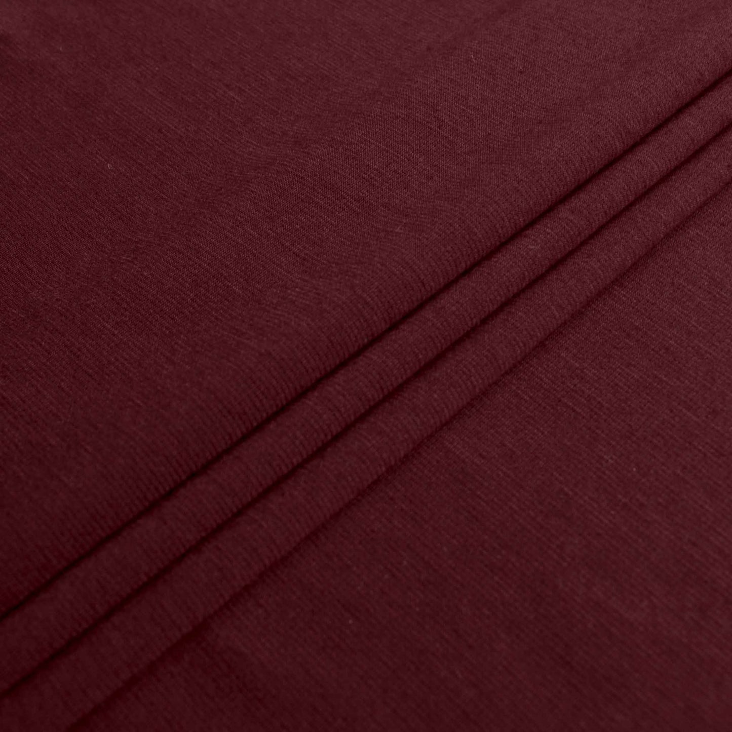 folded maroon jersey knit ponte roma dressmaking fabric 