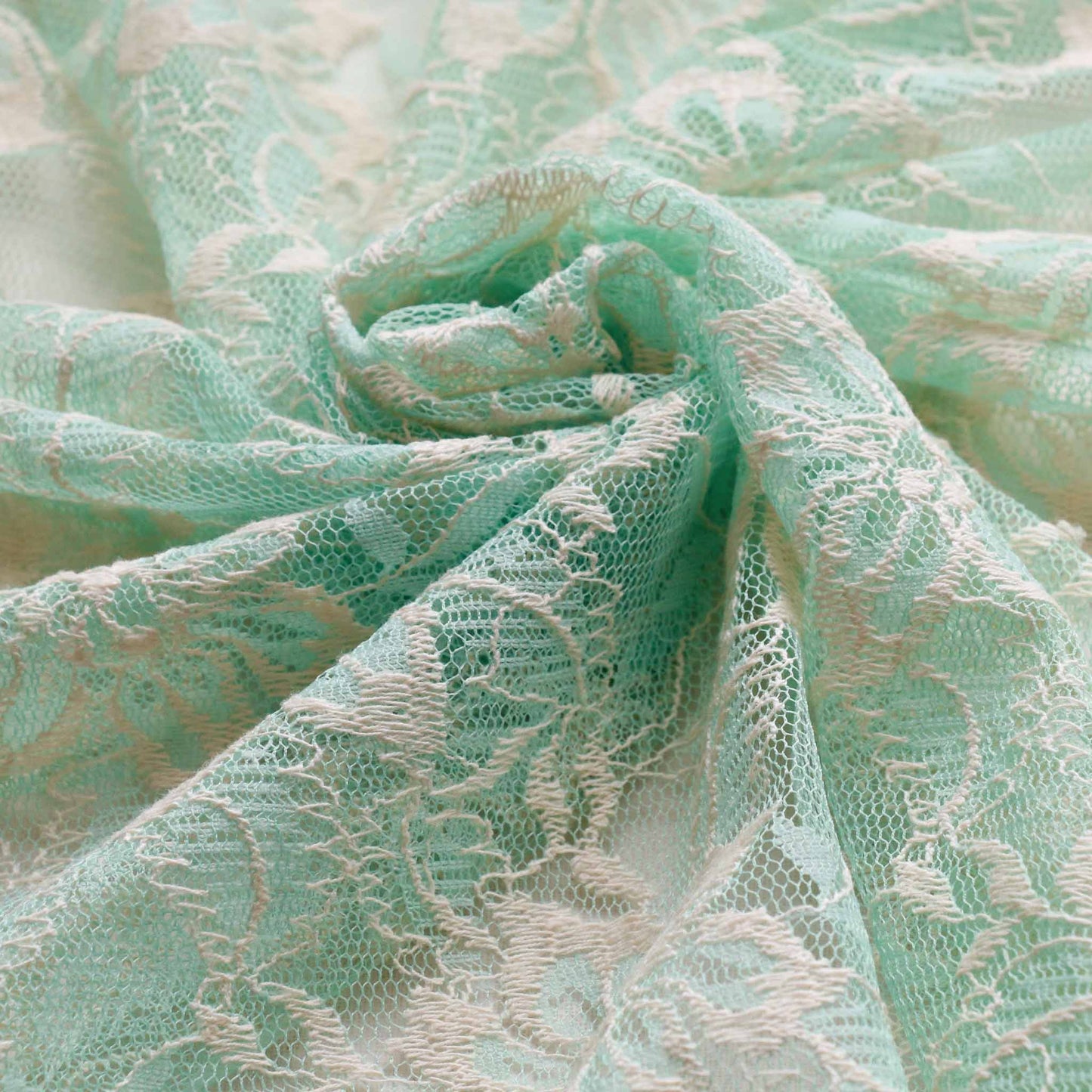 cool mint and cream dressmaking lace fabric with floral design