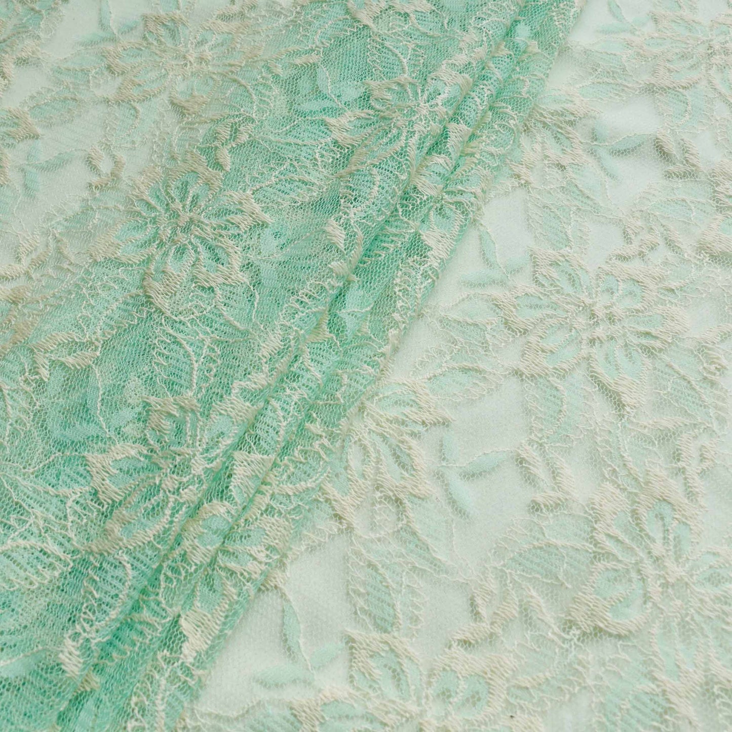 cool mint and cream lace fabric for dressmaking with delicate floral design