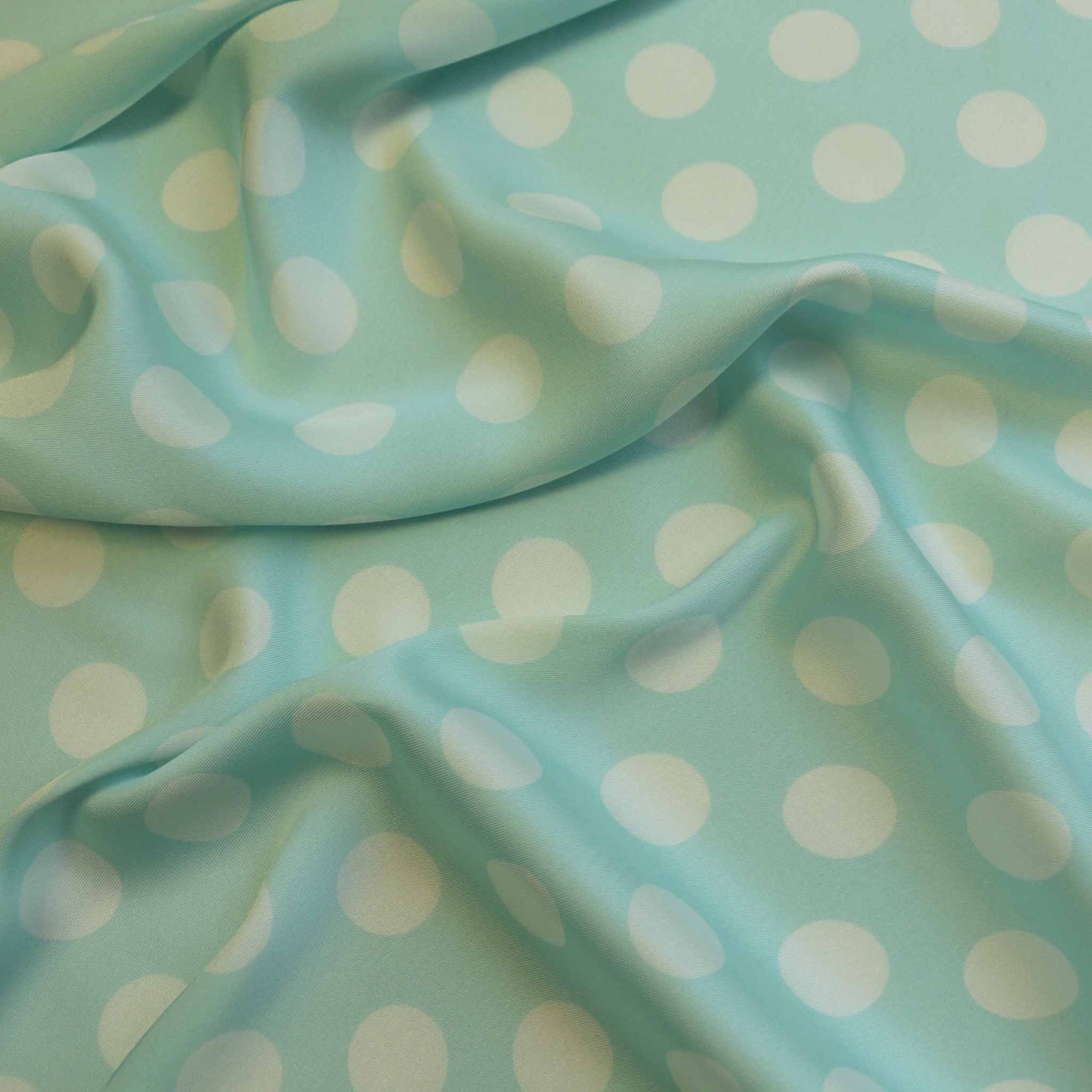 mint satin twill dressmaking fabric with large white polka dot print
