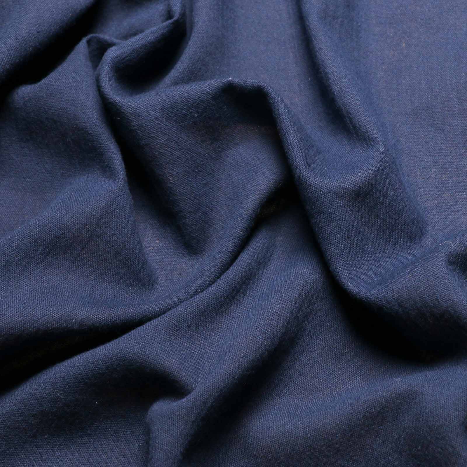 close up of crinkle cotton gauze dressmaking fabric in plain navy blue