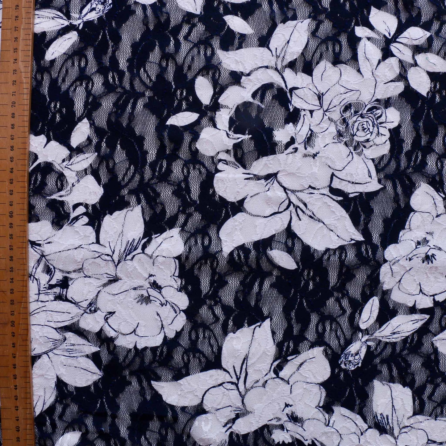 metre navy and white floral dressmaking lace fabric with large white flowers on delicate pattern