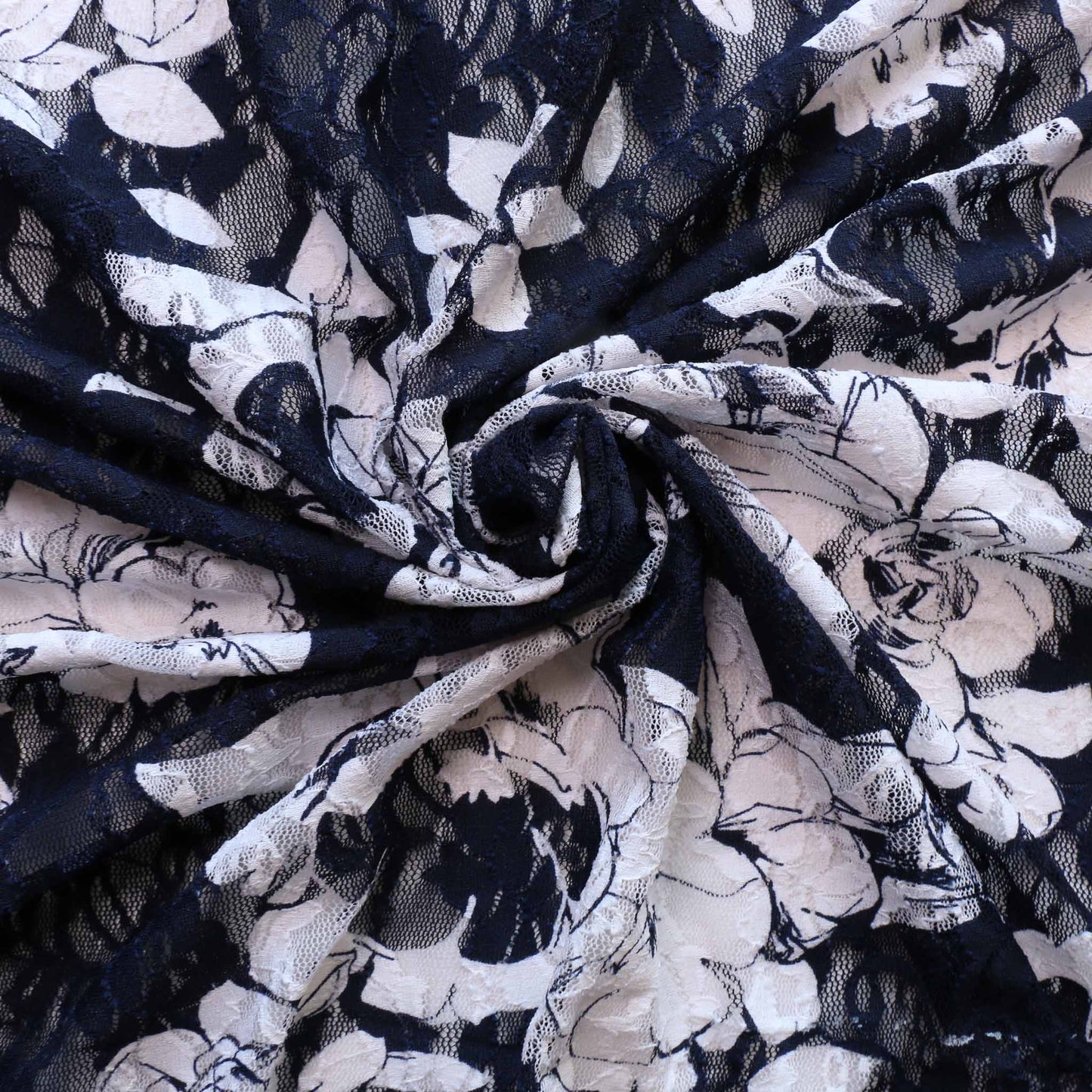 large white flower design on navy blue stretchy dressmaking lace fabric